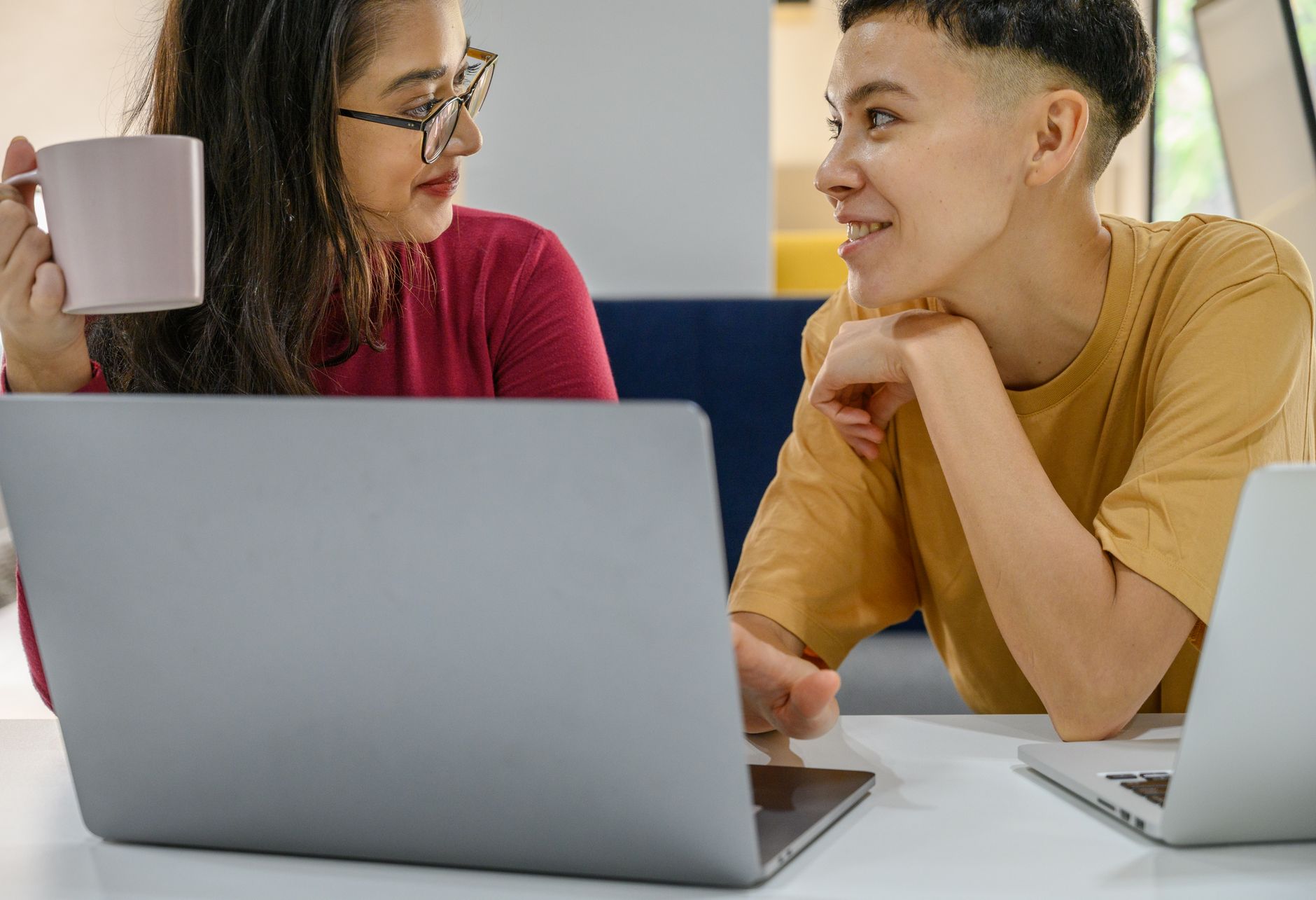 Two colleagues comparing a personal LinkedIn profile with the company page