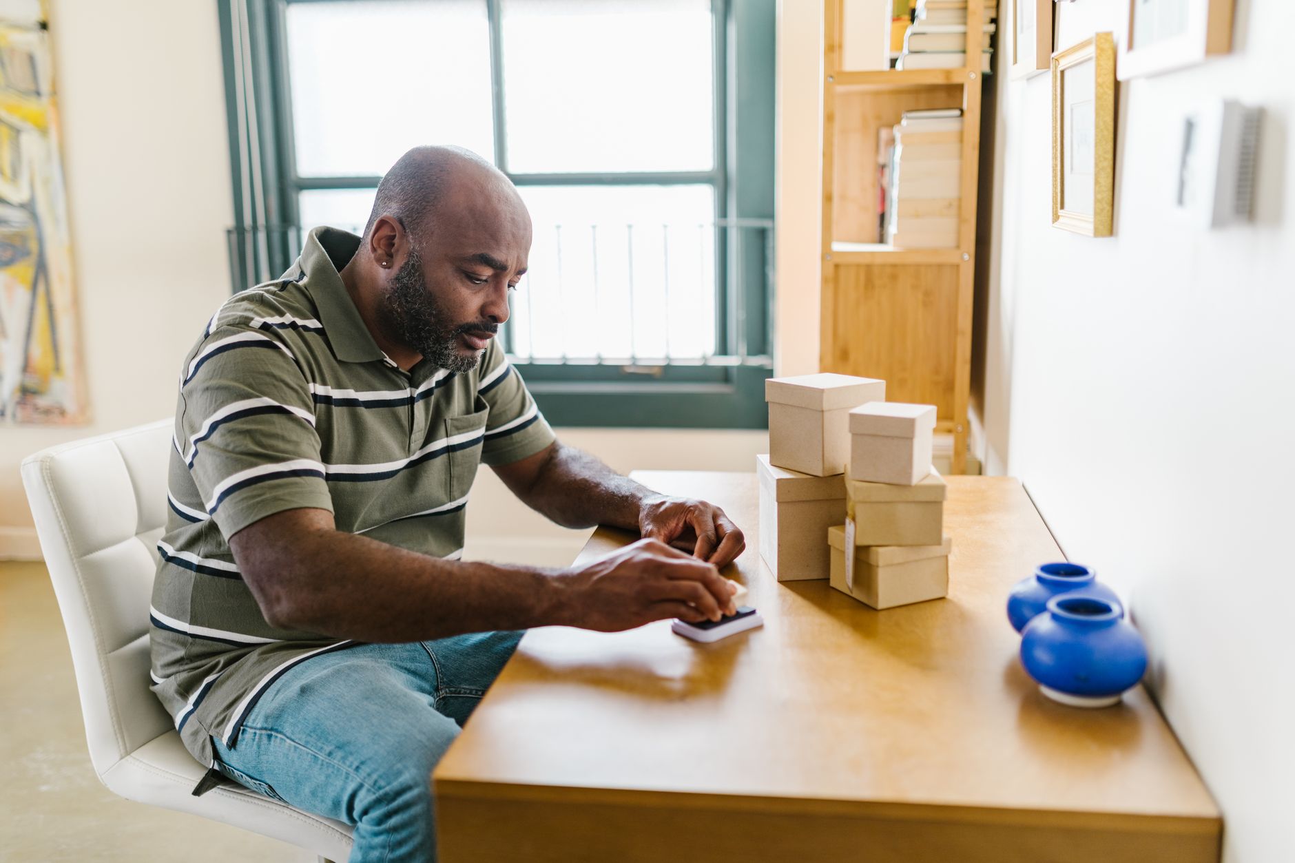 A potter packing finished work into consistently branded boxes