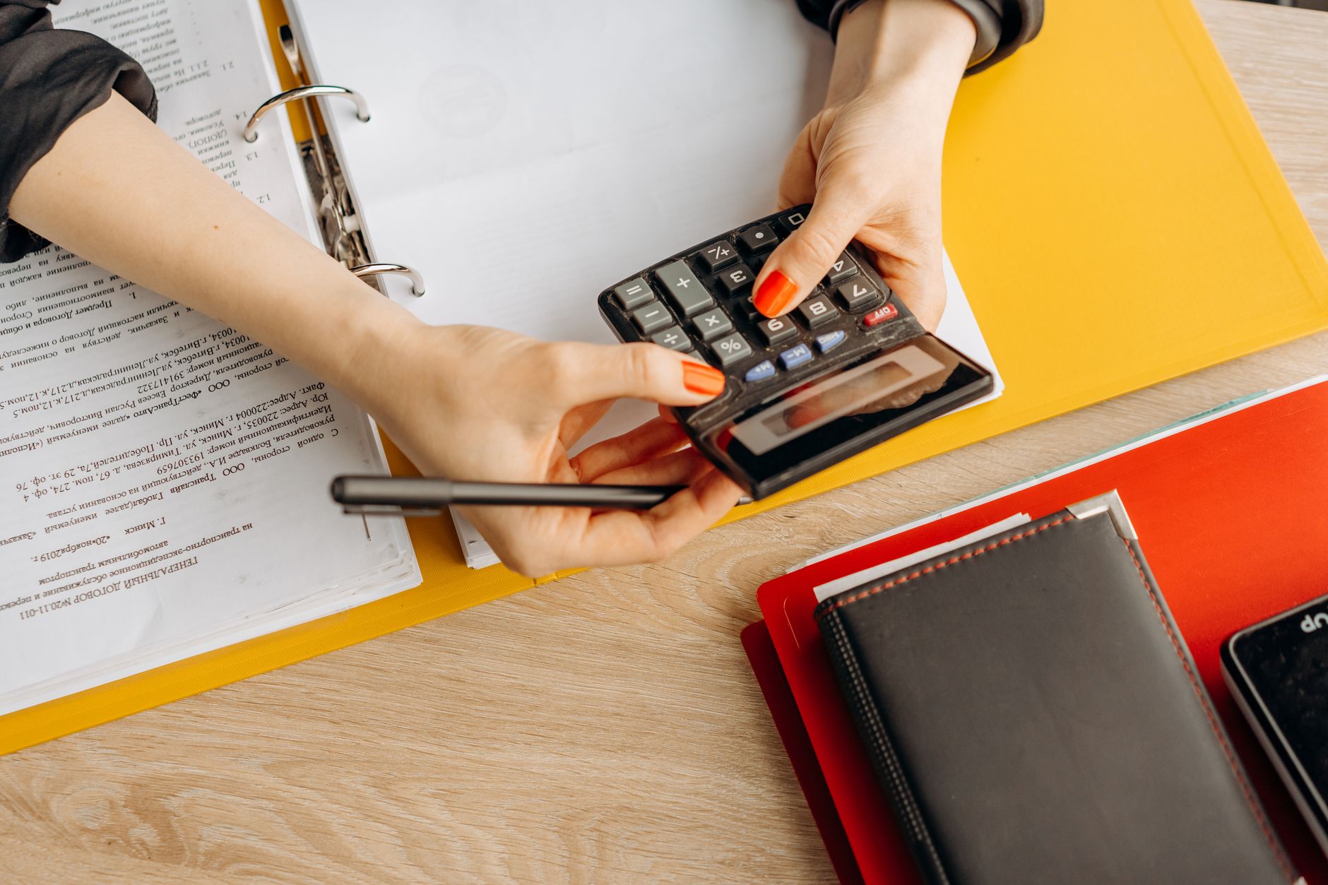 A bookkeeper working with stationery in a distinctive brand colour