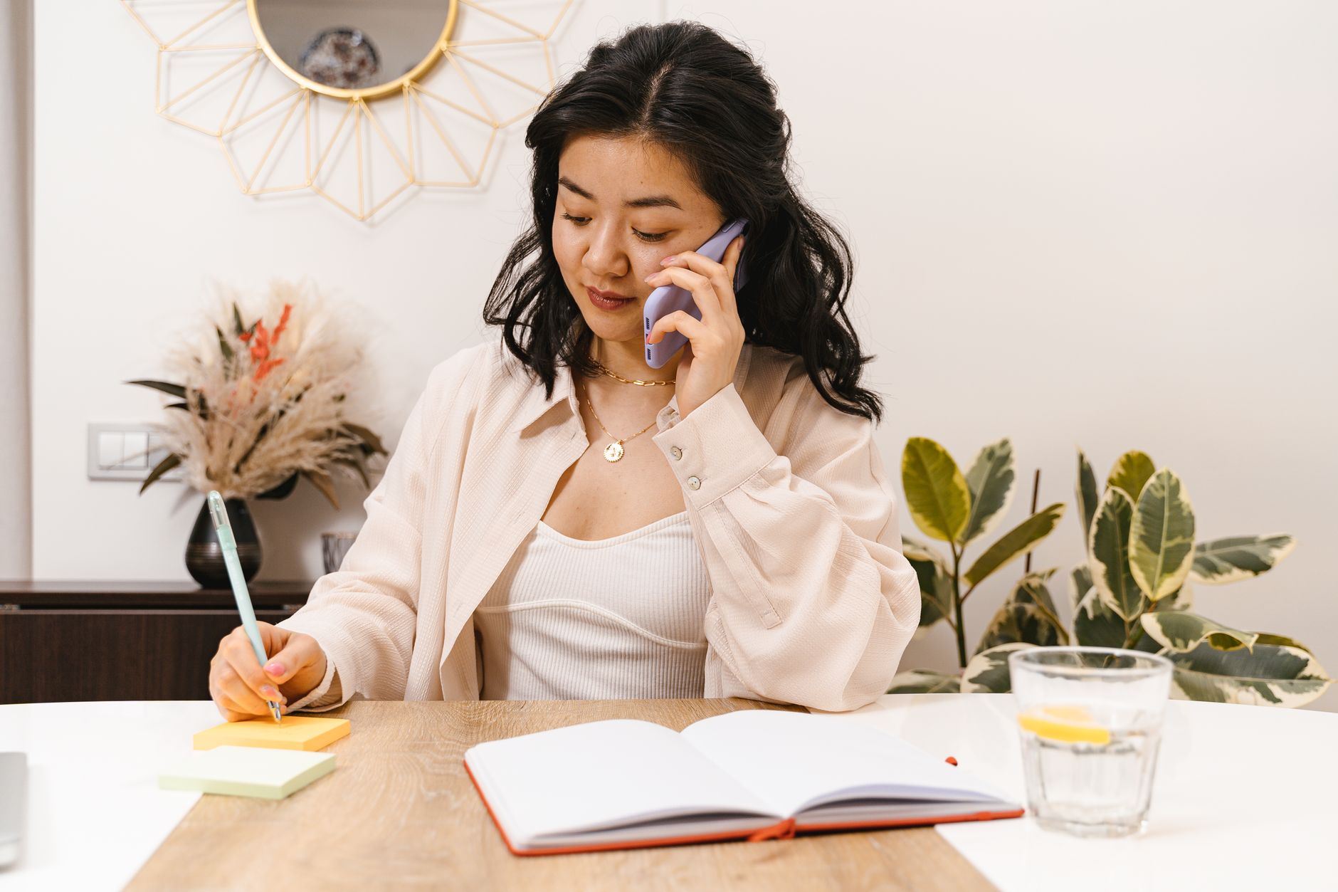 A business owner on a call with a potential customer, taking notes