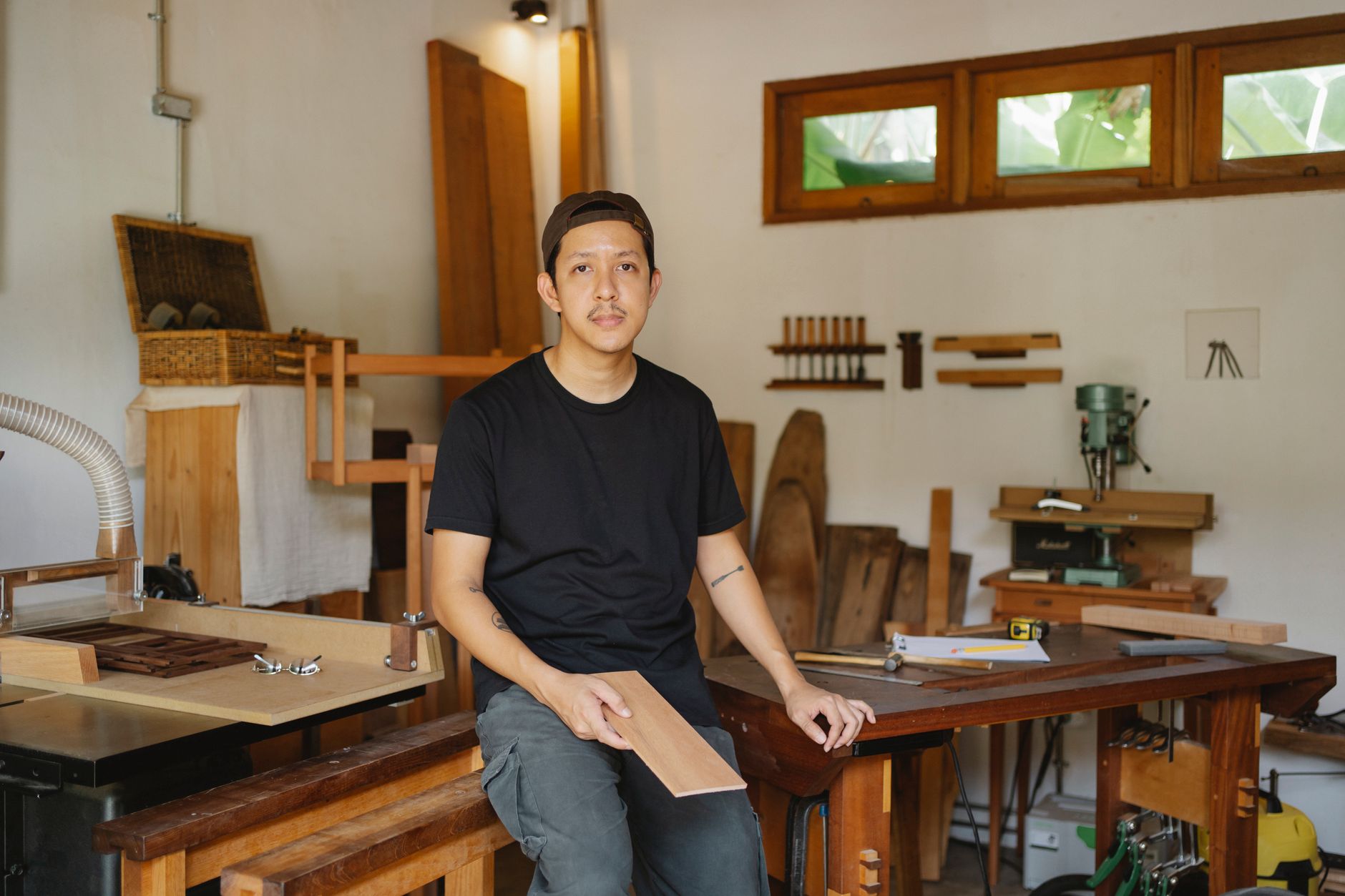 A joiner working in his workshop, surrounded by materials and costs