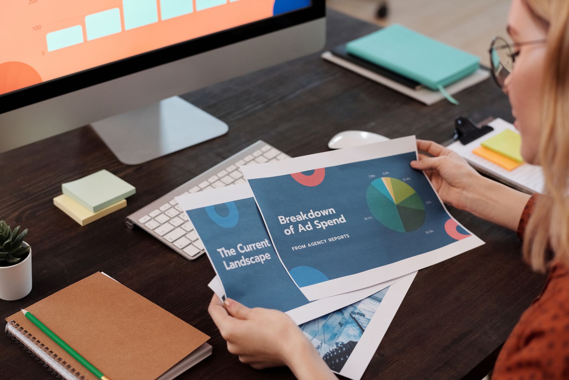 A marketing manager reviewing budget reports at an office table