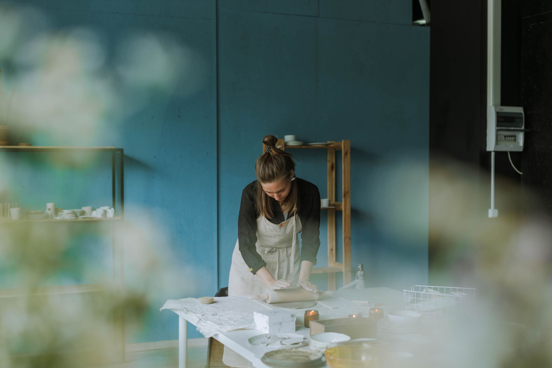 A potter setting out handmade tableware for a customer