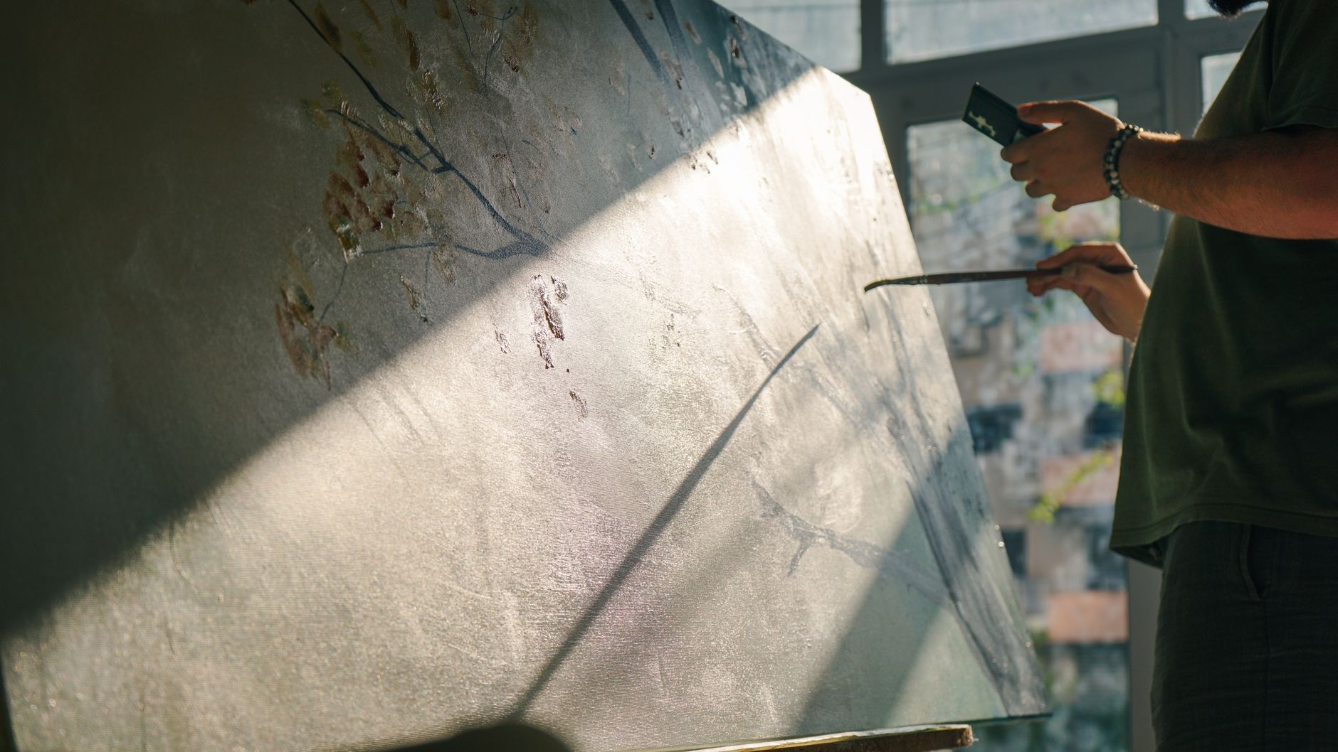 An artist filming behind the scenes footage of a painting in progress