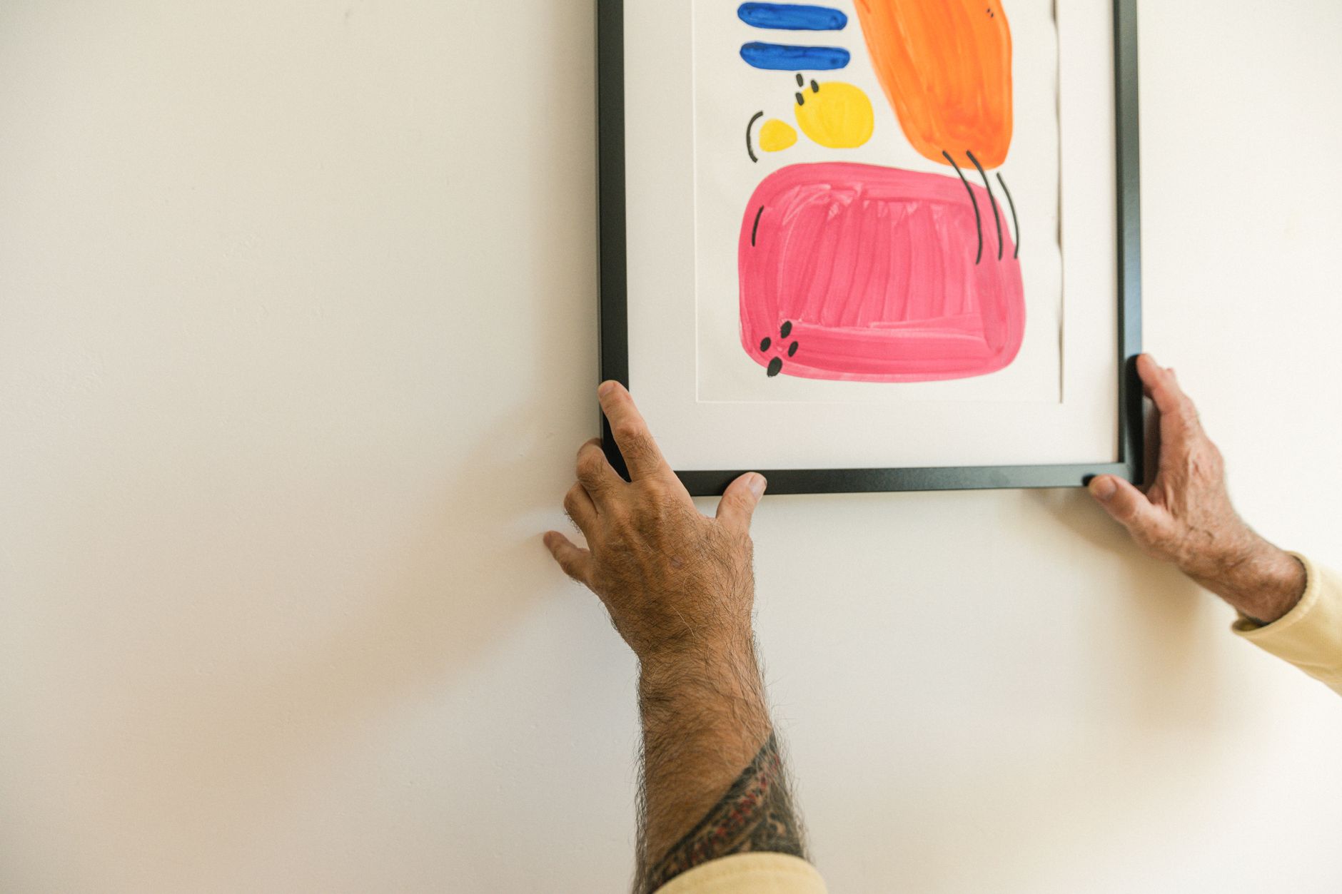 A customer hanging a newly bought painting in their home