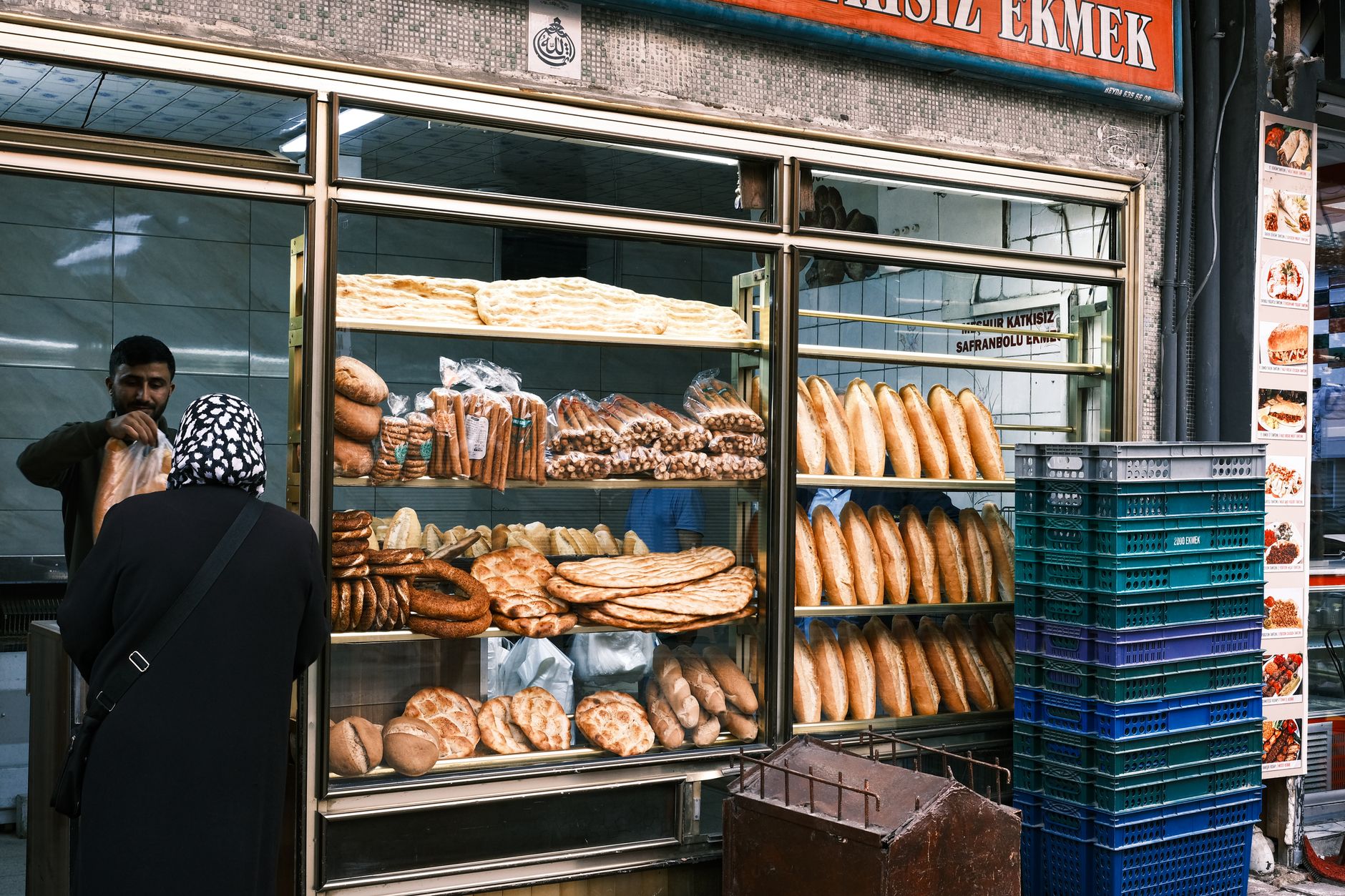A baker arranging fresh bread in the shop window