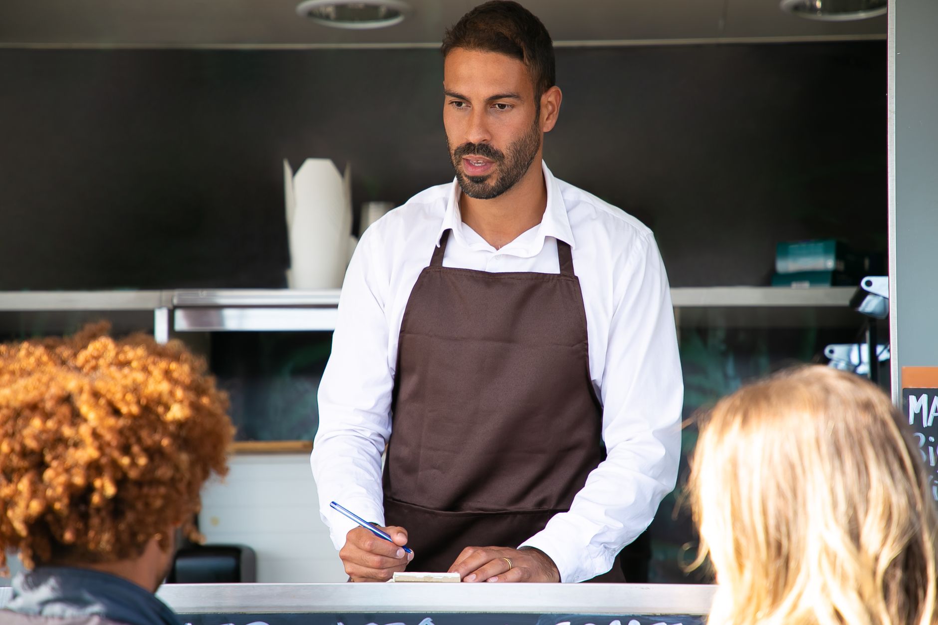 A bakery owner serving a regular customer by name