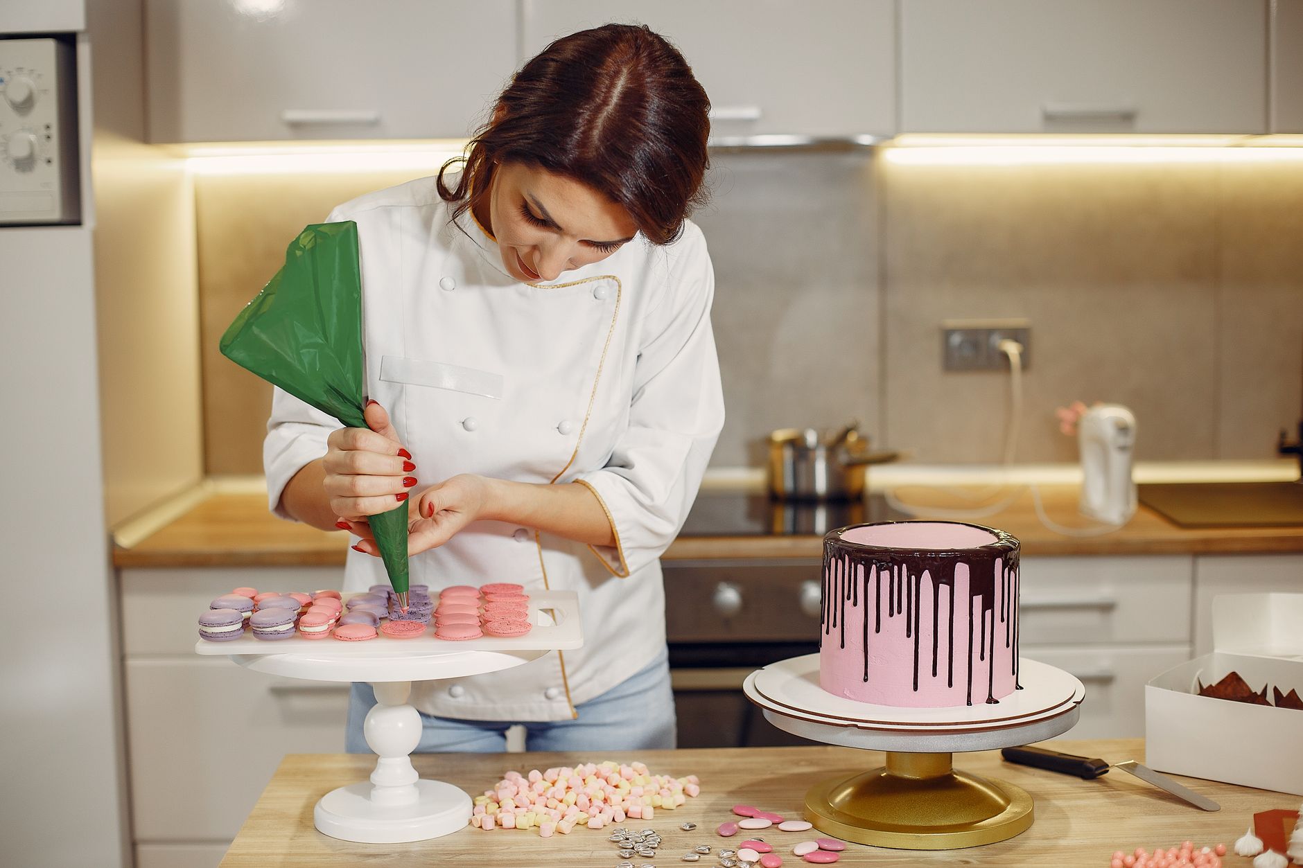 A baker decorating a wedding cake in their workshop
