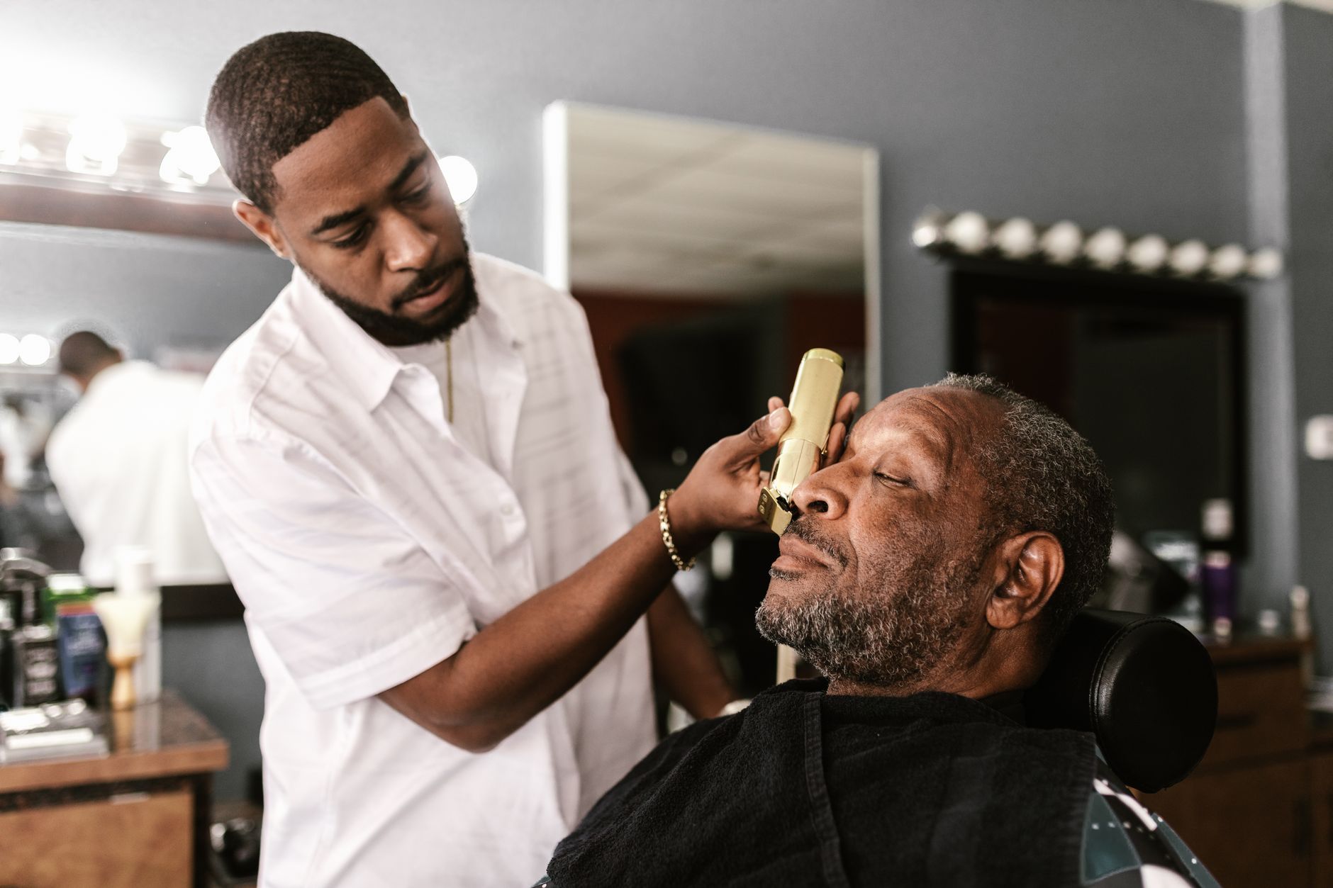 A barber talking with a returning client mid-haircut