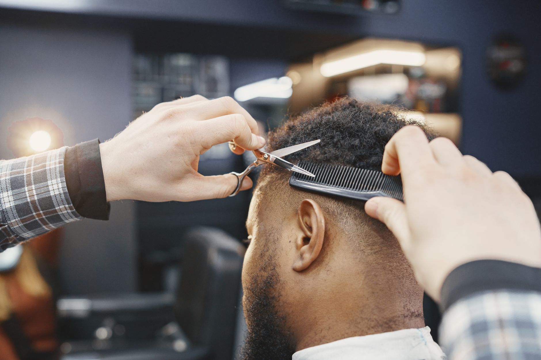 A barber taking a photo of a finished cut to share