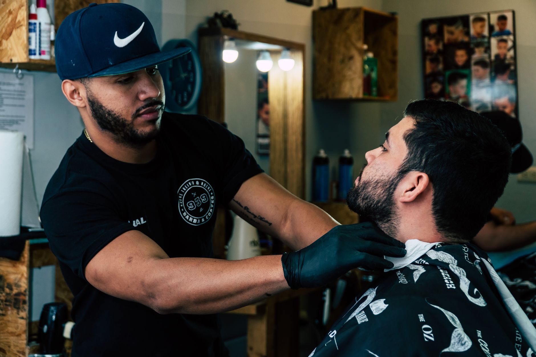 A barber giving a client a fade in a busy independent shop