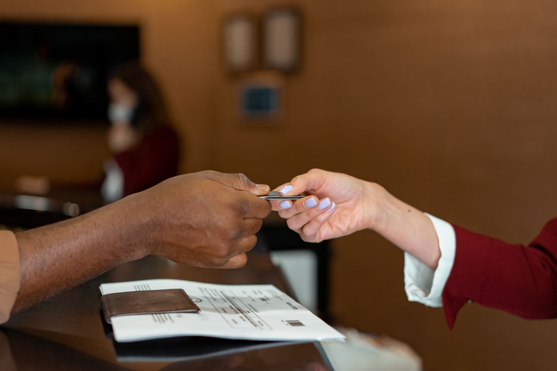 A beautician giving a client a referral offer at the counter