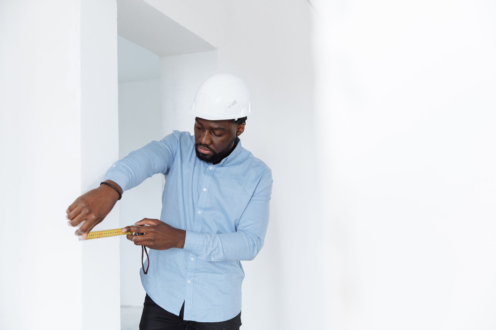 A builder measuring a loft space as part of a specialist conversion
