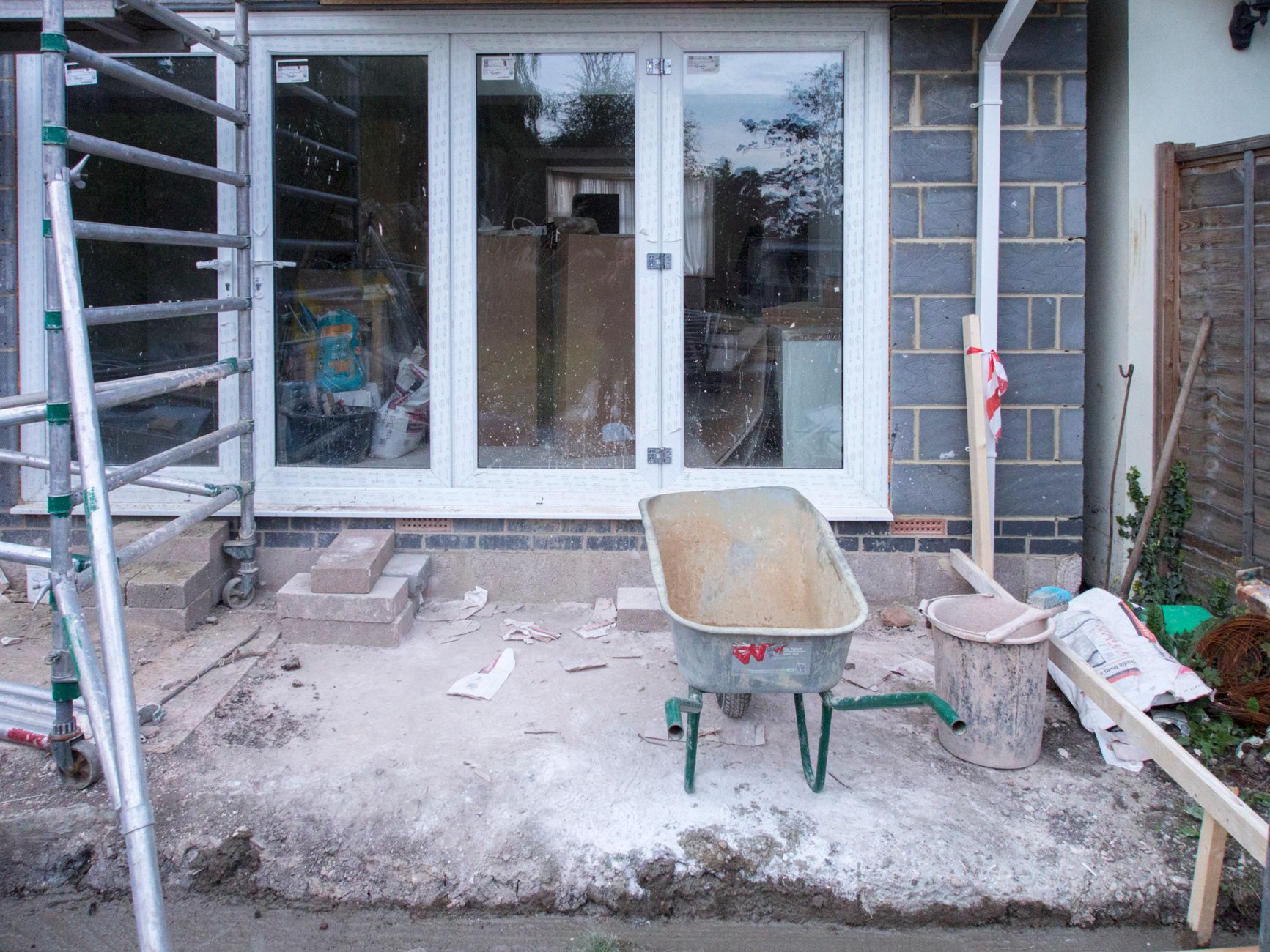 A builder standing proudly beside his van outside a completed house extension
