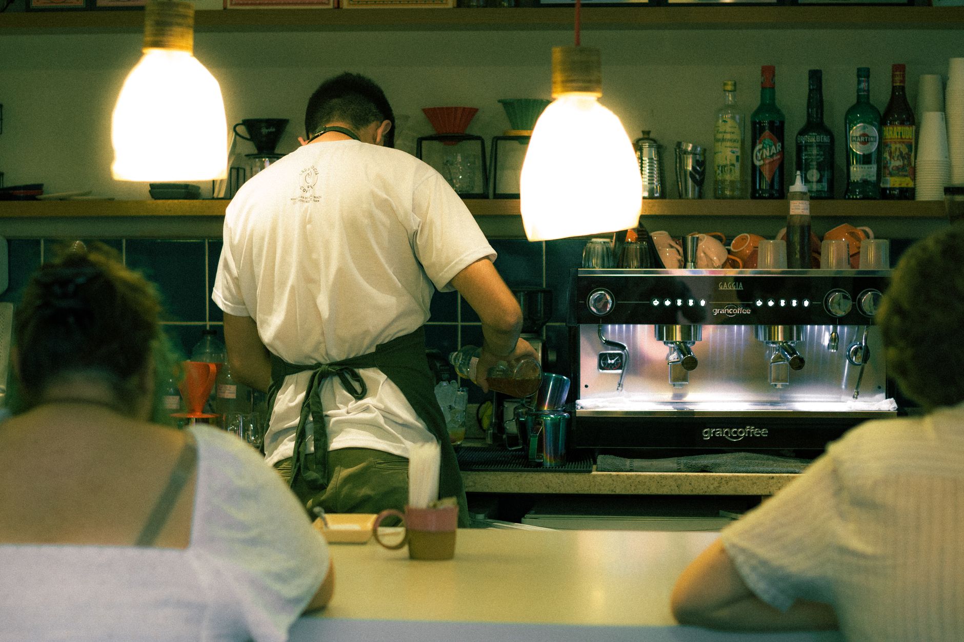 A barista preparing coffee in a busy independent cafe