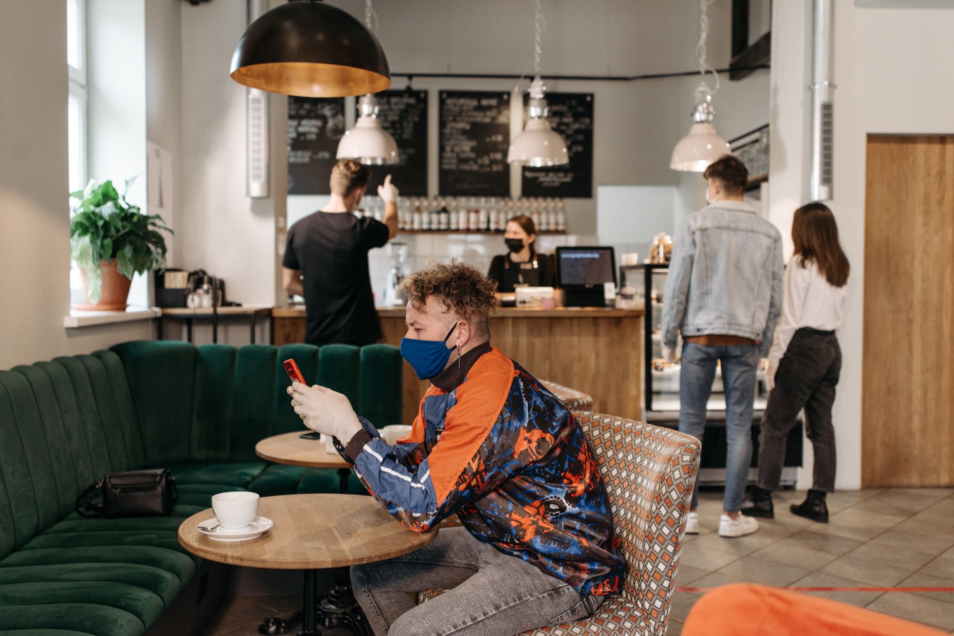A cafe owner checking their business listing near the till