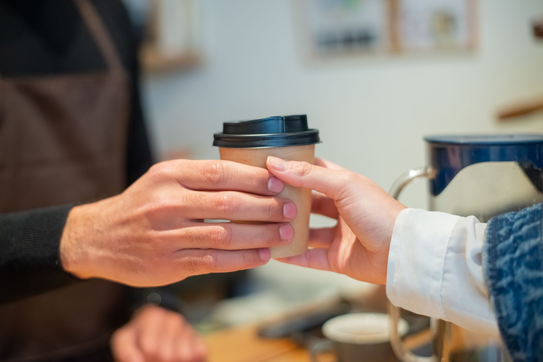 A barista handing a customer a cup with distinctive latte art