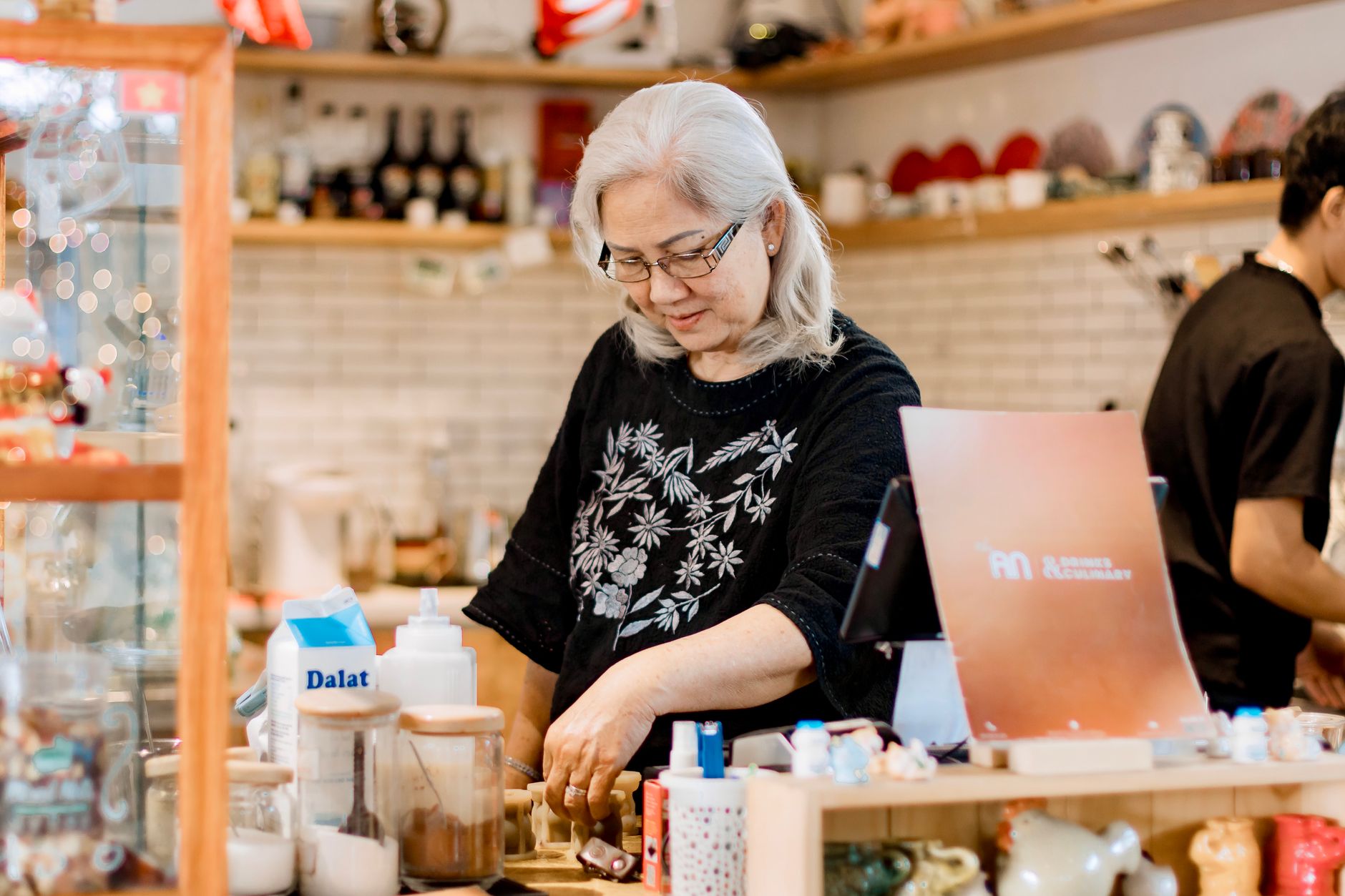 A cafe owner stamping a loyalty card for a returning customer