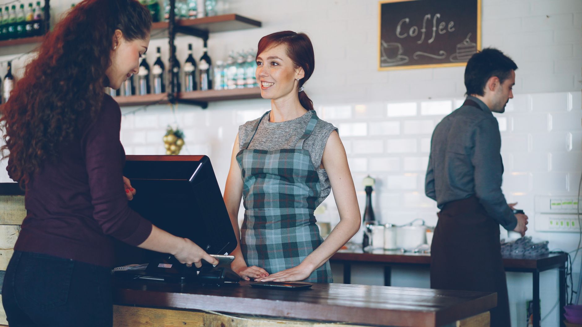 A cafe owner serving a regular customer at the counter