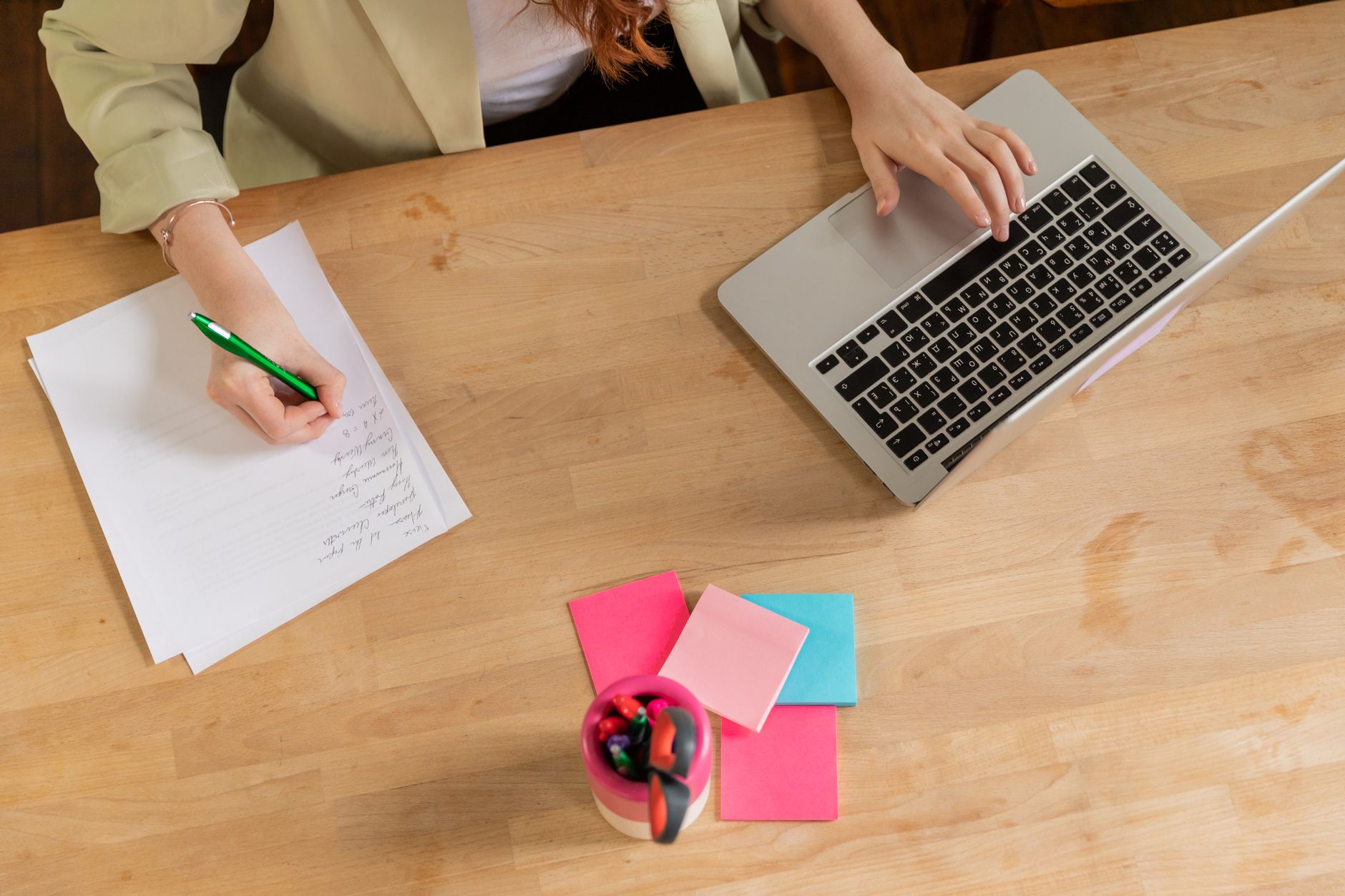 A charity worker drafting a newsletter with handwritten notes nearby