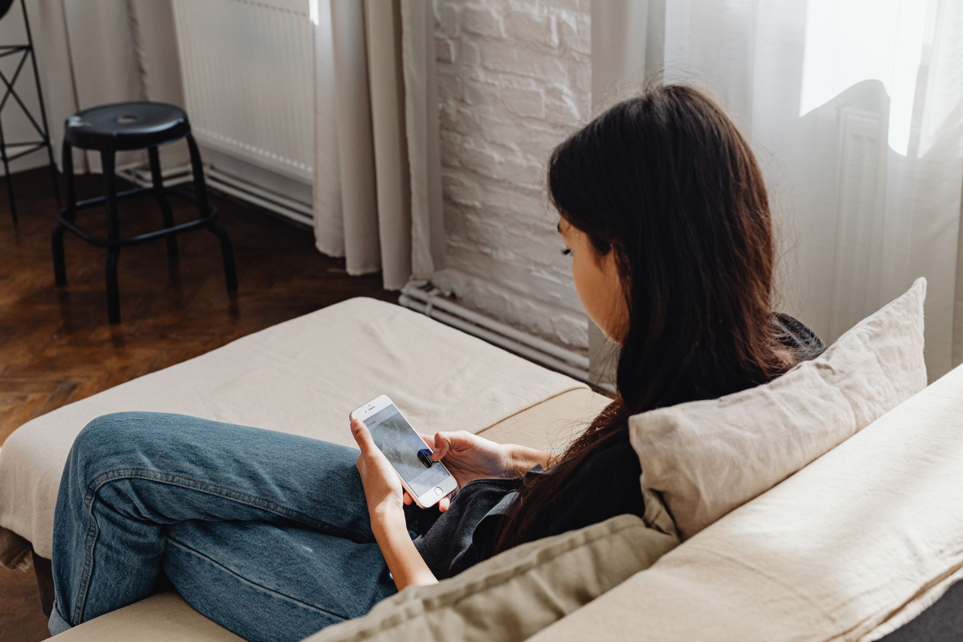 A person in discomfort searching for a local chiropractor on their phone