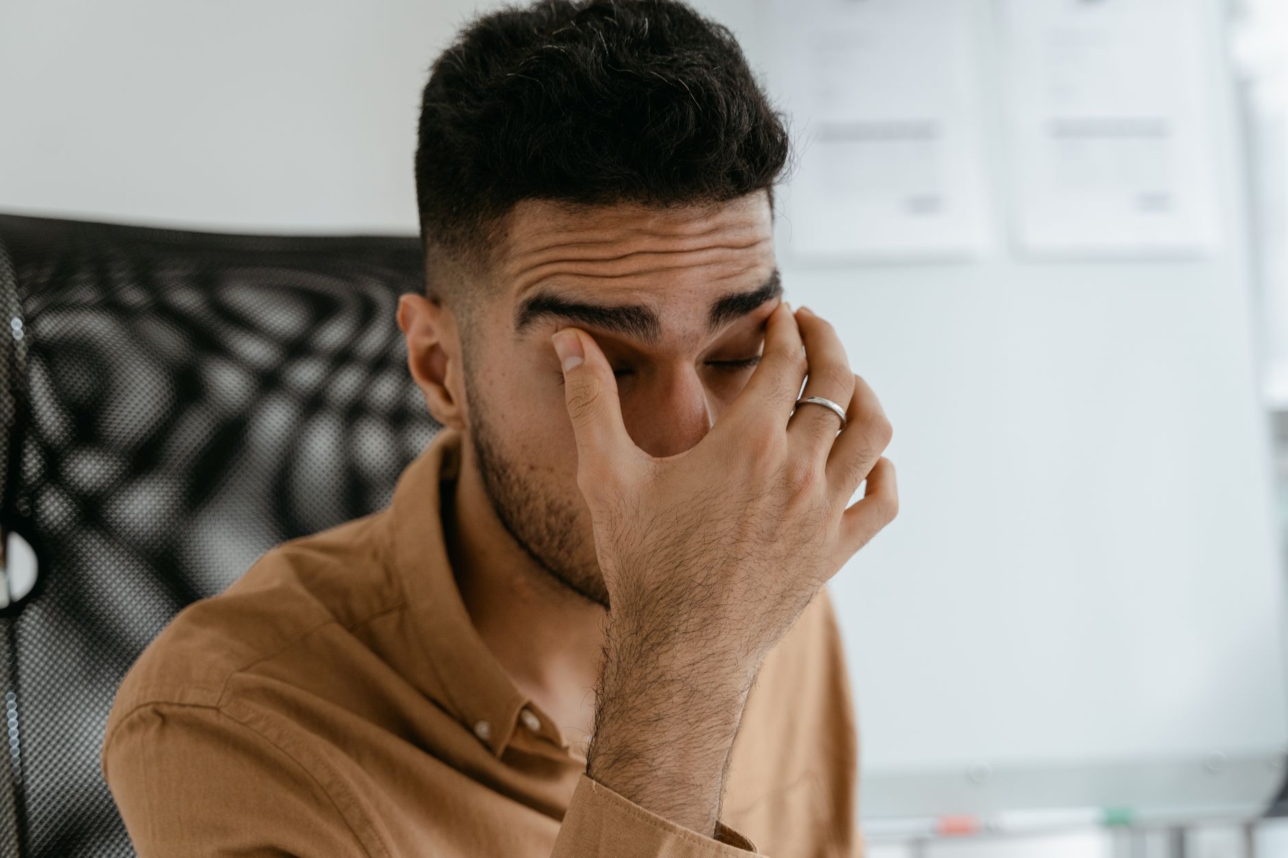 An office worker experiencing the neck and back strain that sends people to a chiropractor