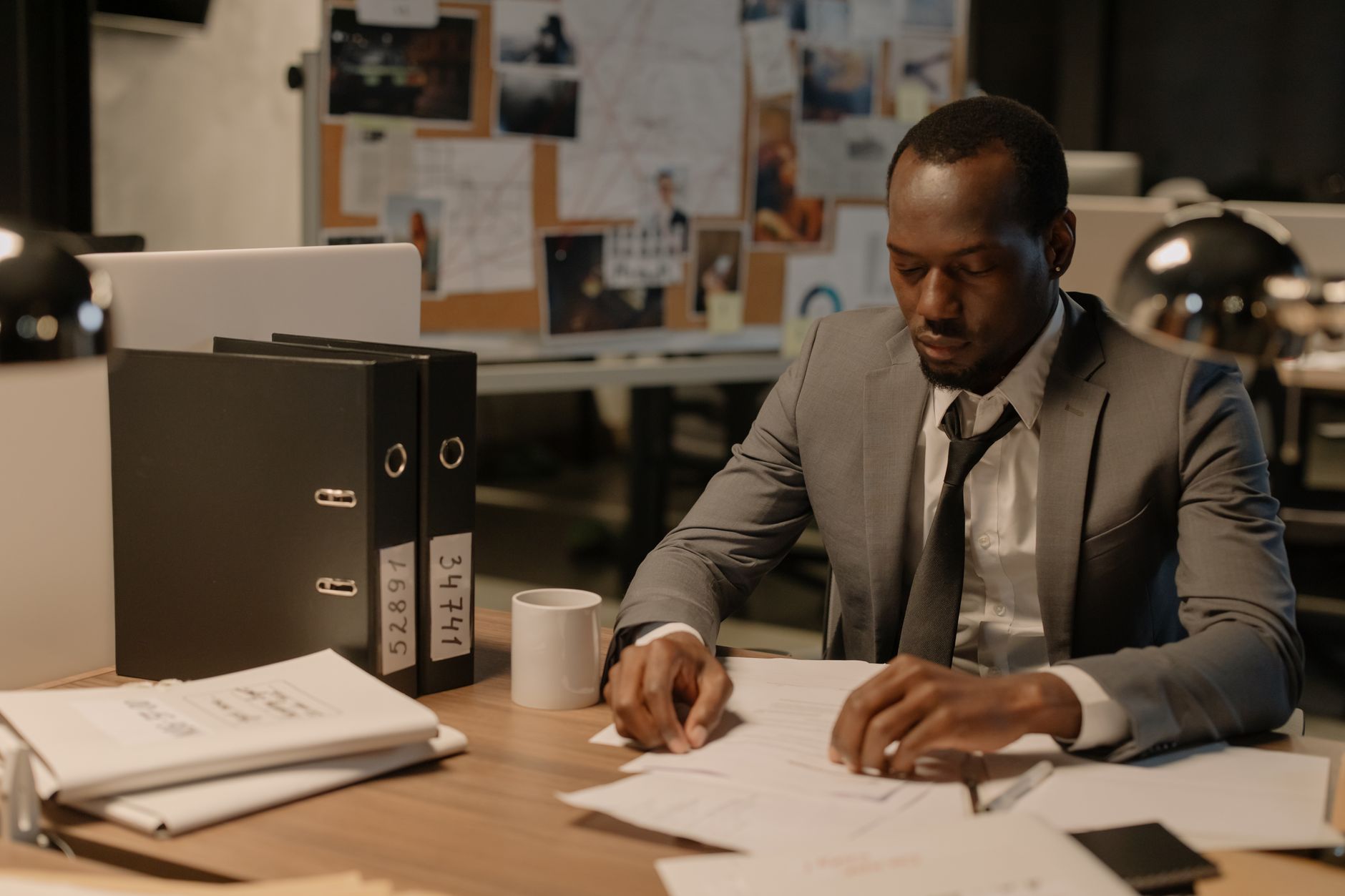 A consultant working through detailed reports late at their desk