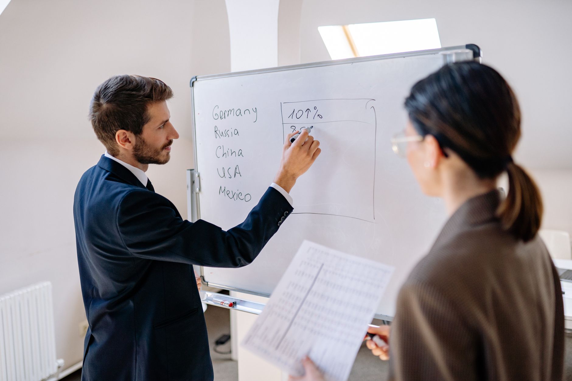 A consultant explaining a specific approach on a whiteboard