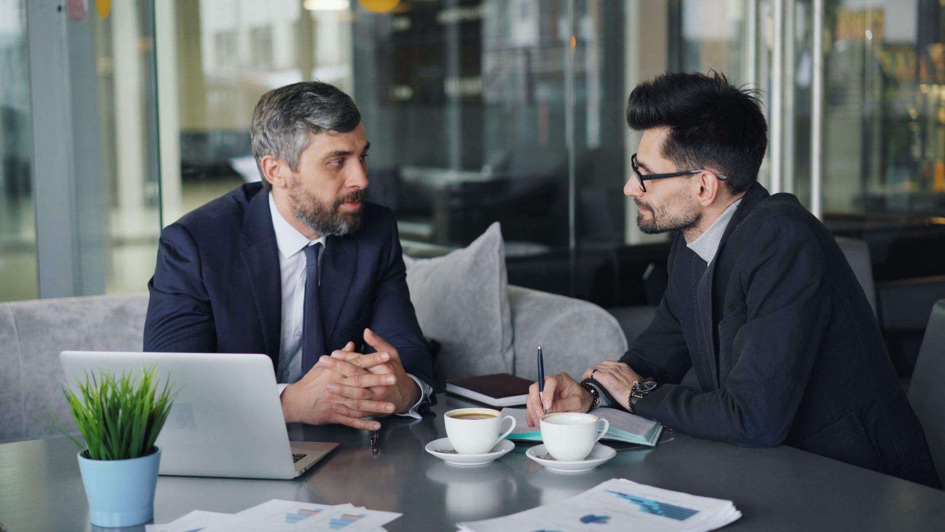 Two colleagues discussing a referral over coffee