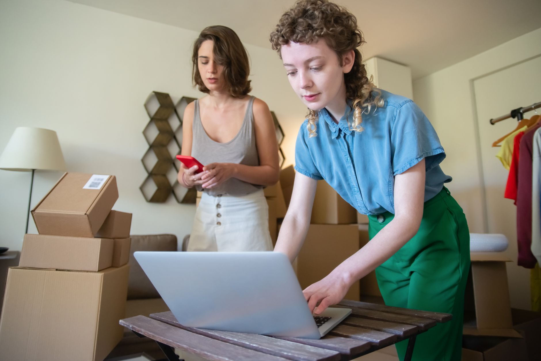 A customer checking their phone while an electrician packs up after a job