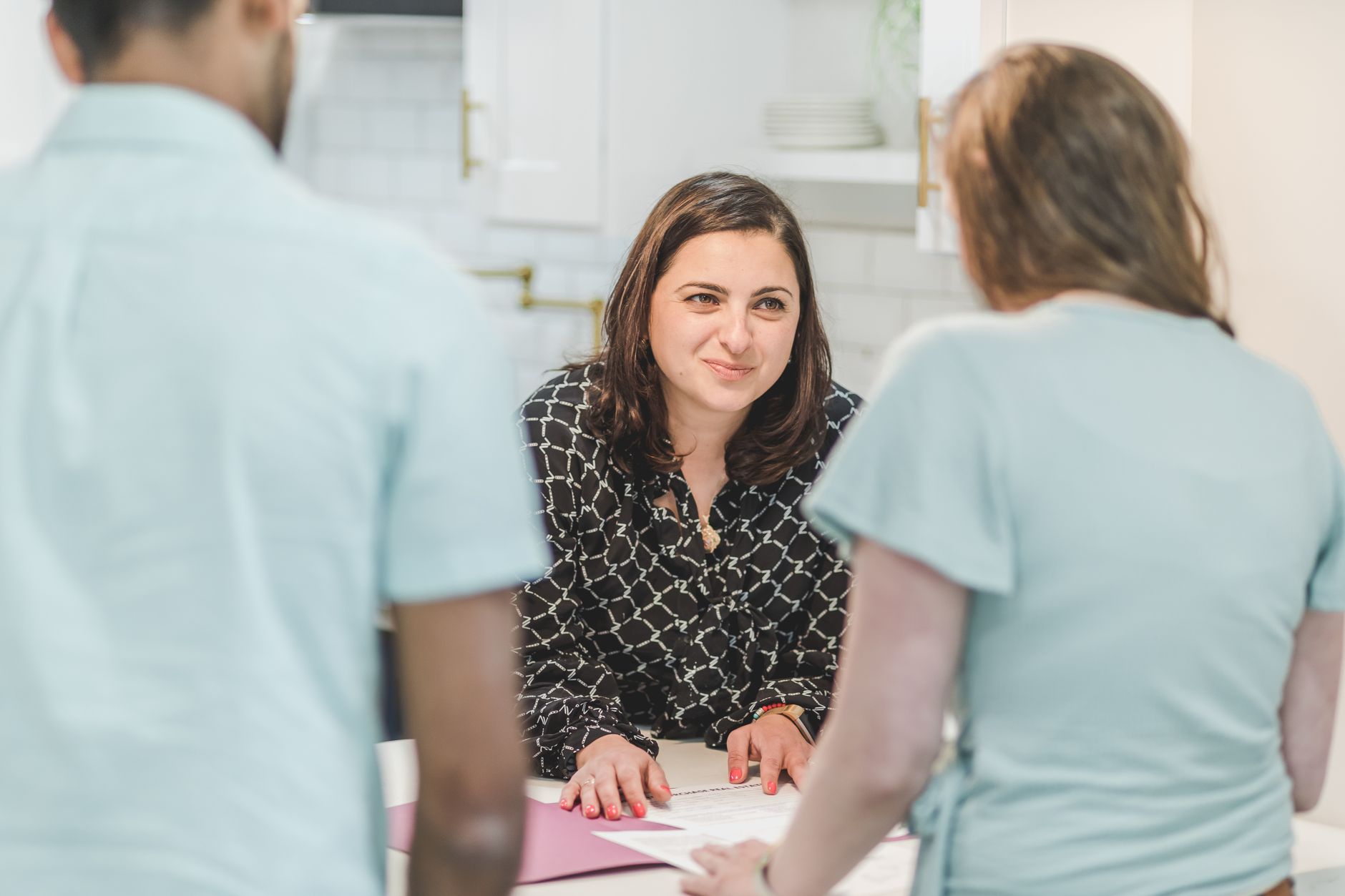 An estate agent discussing a valuation with a homeowner at their kitchen table