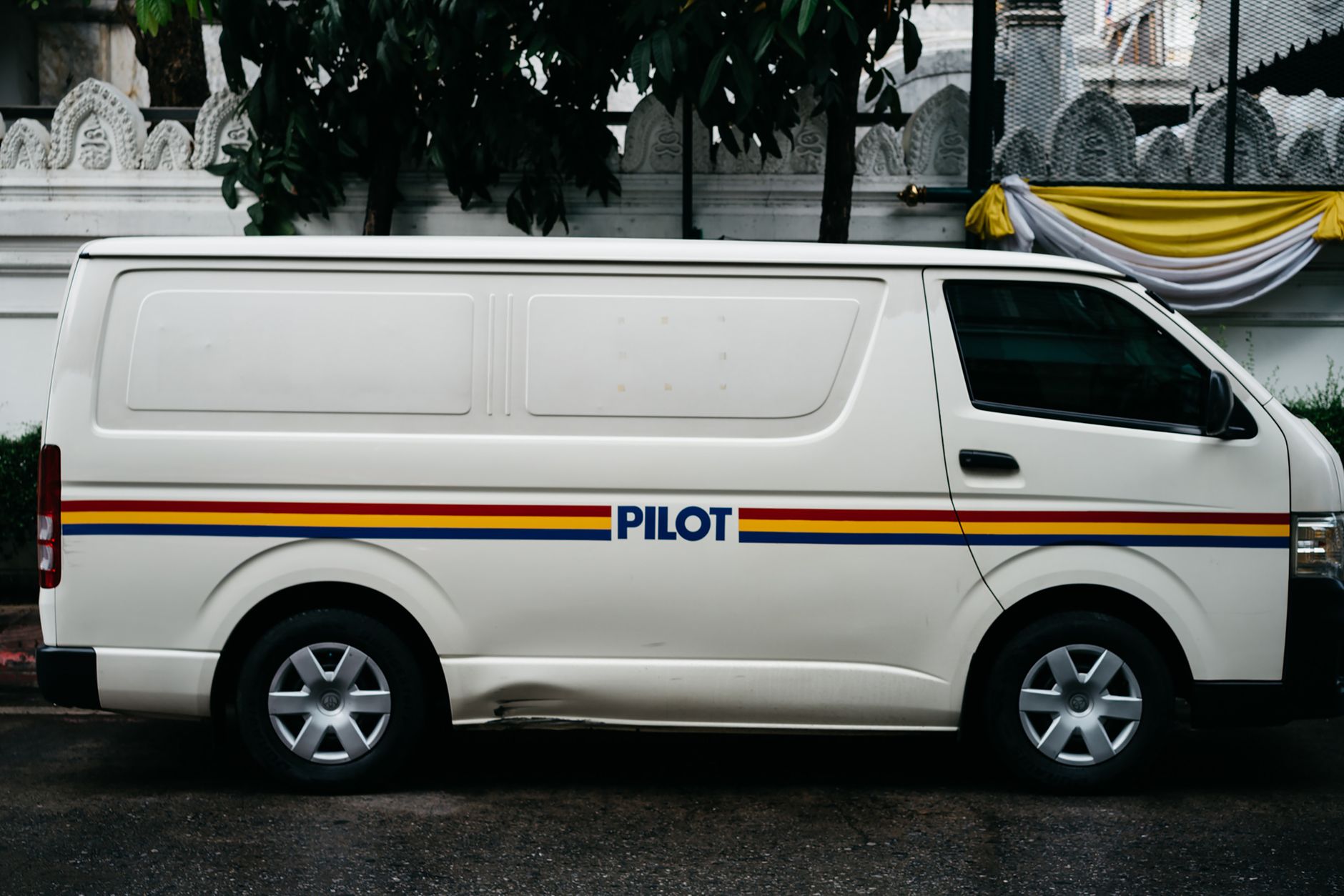 A branded estate agent van parked outside homes on a quiet street