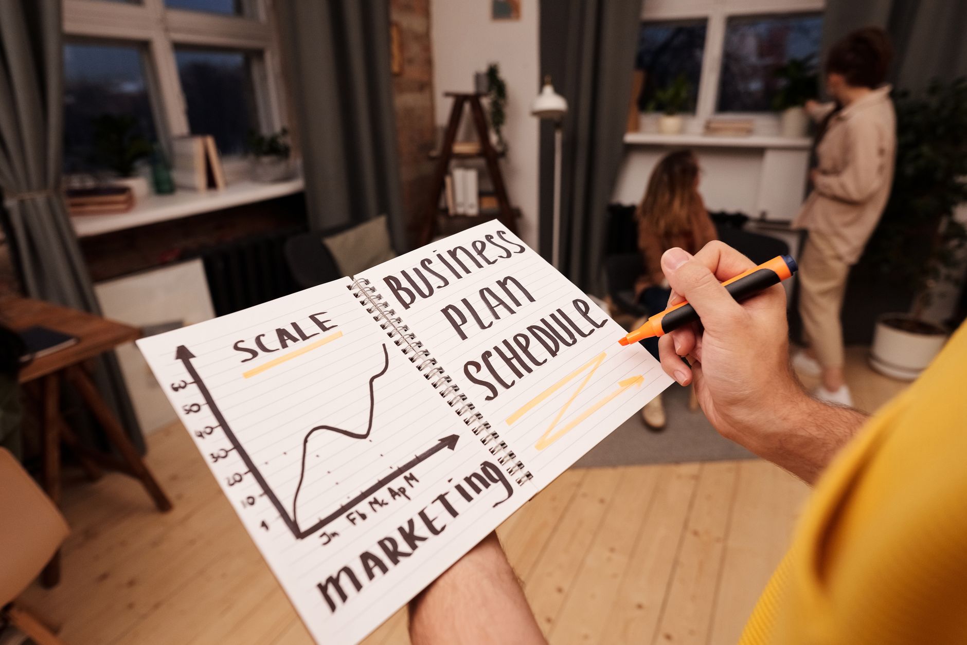A gym owner planning their marketing at a small office desk