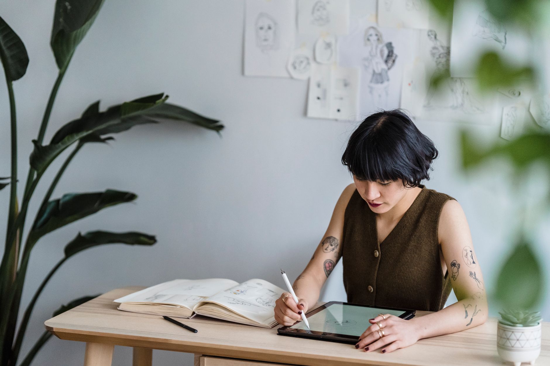 An illustrator working at a drawing tablet in a home studio