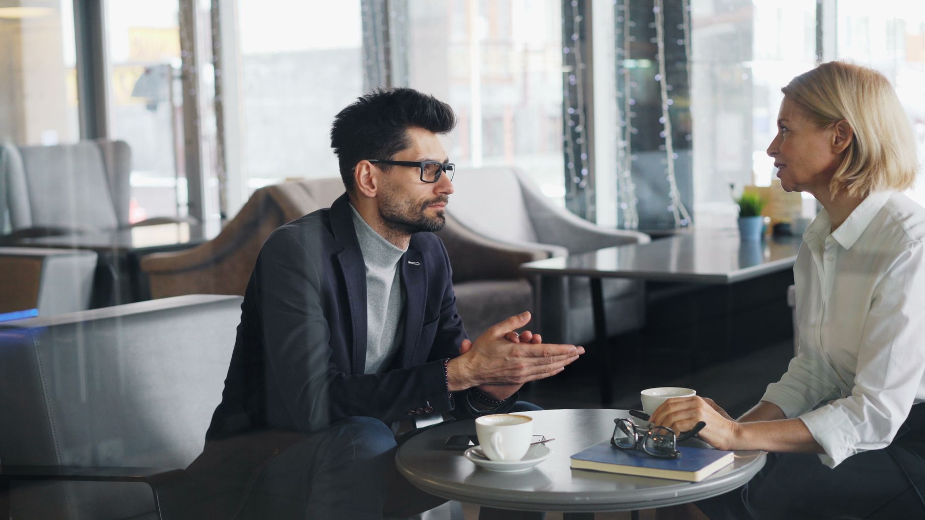 An interior designer and a client discussing a project over coffee