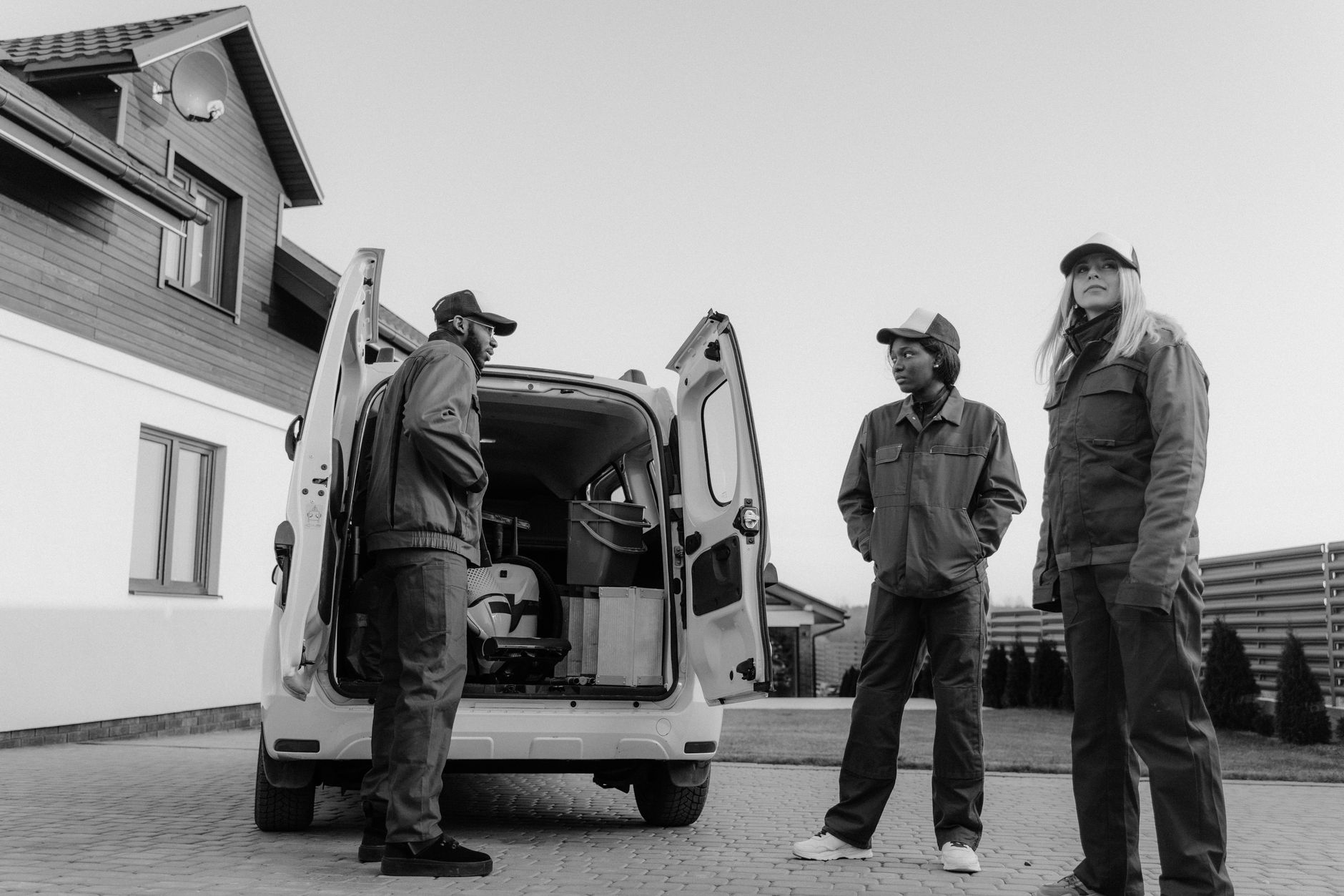 A landscaper unloading a branded van outside a customer's house