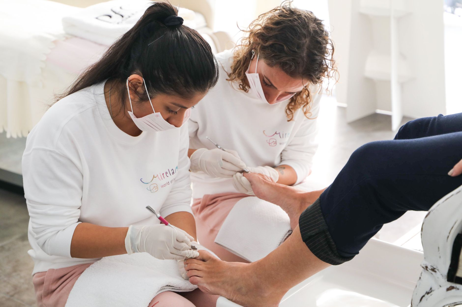 A nail technician talking through pricing and options with a client