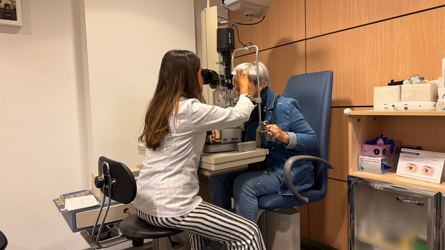 A patient being welcomed into a local optician practice