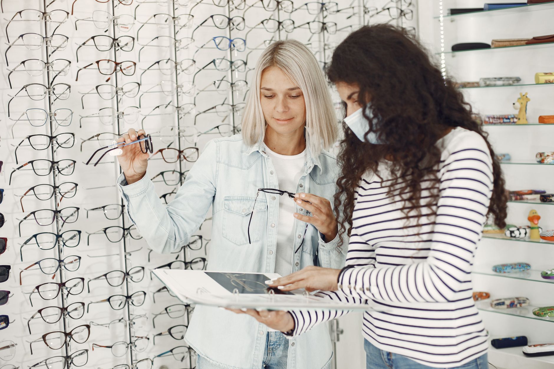 An optician owner talking with a local customer outside the practice