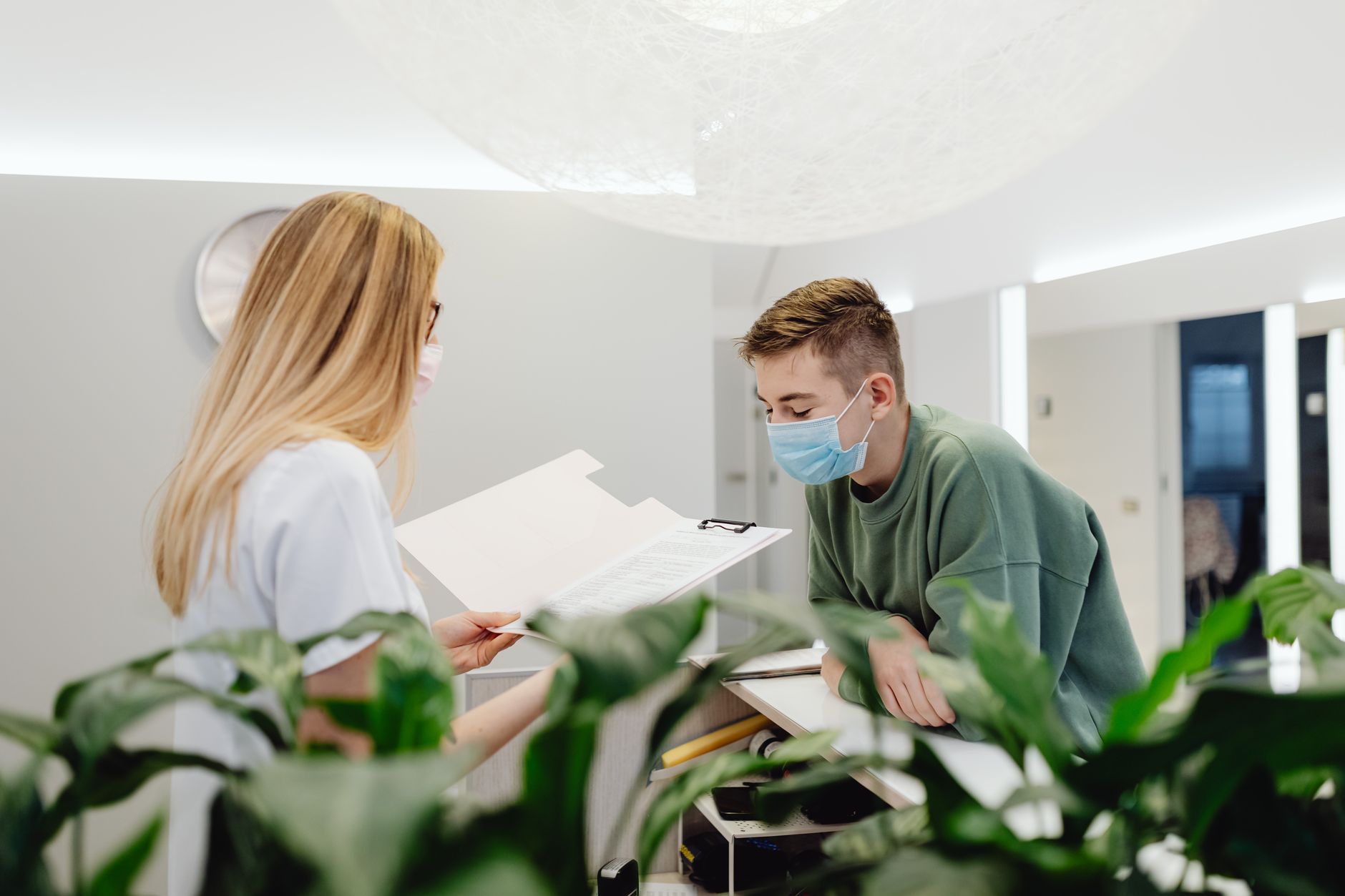 An optician and colleague reviewing bookings at the practice counter