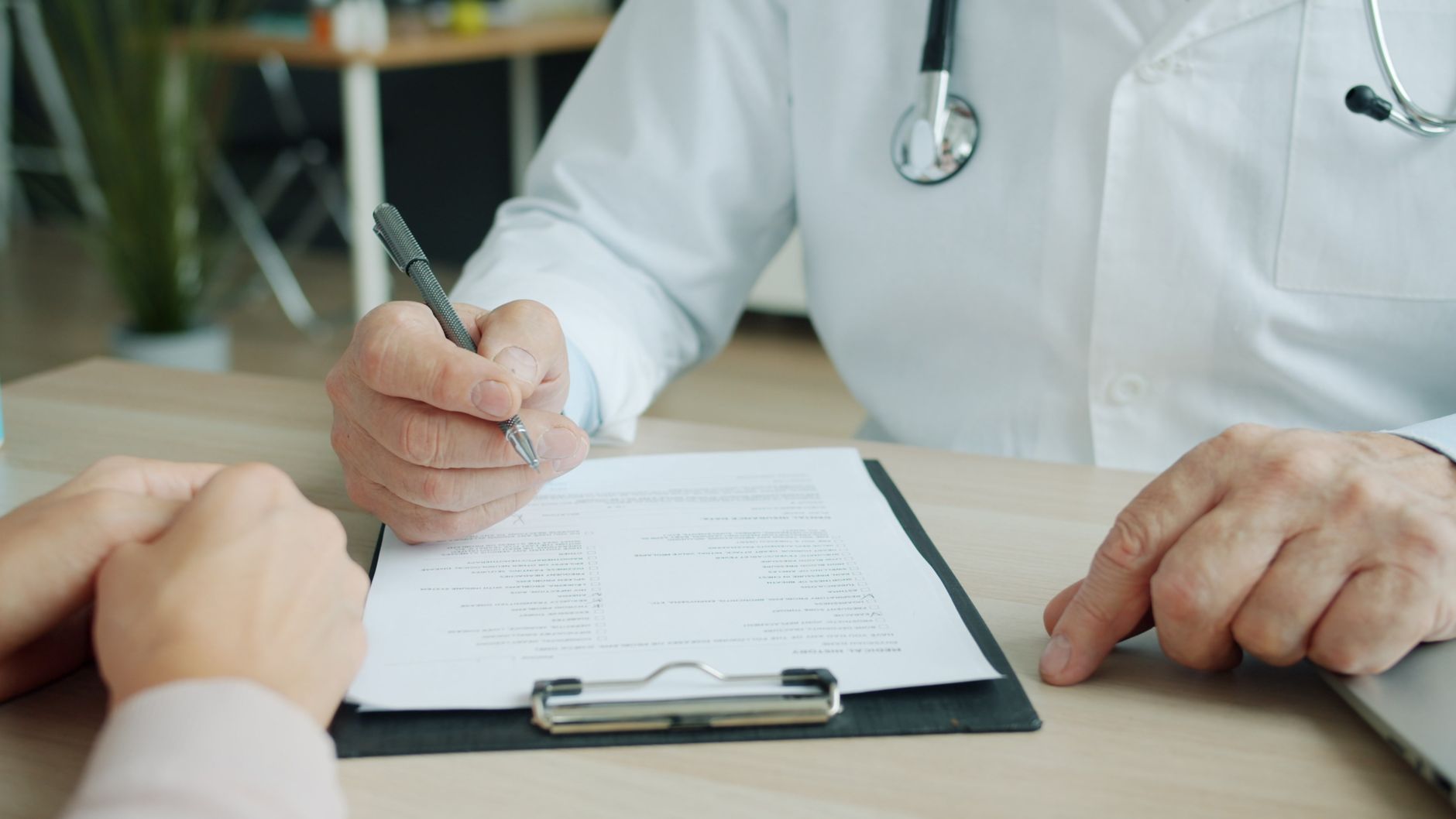 An osteopath discussing insurance cover with a patient