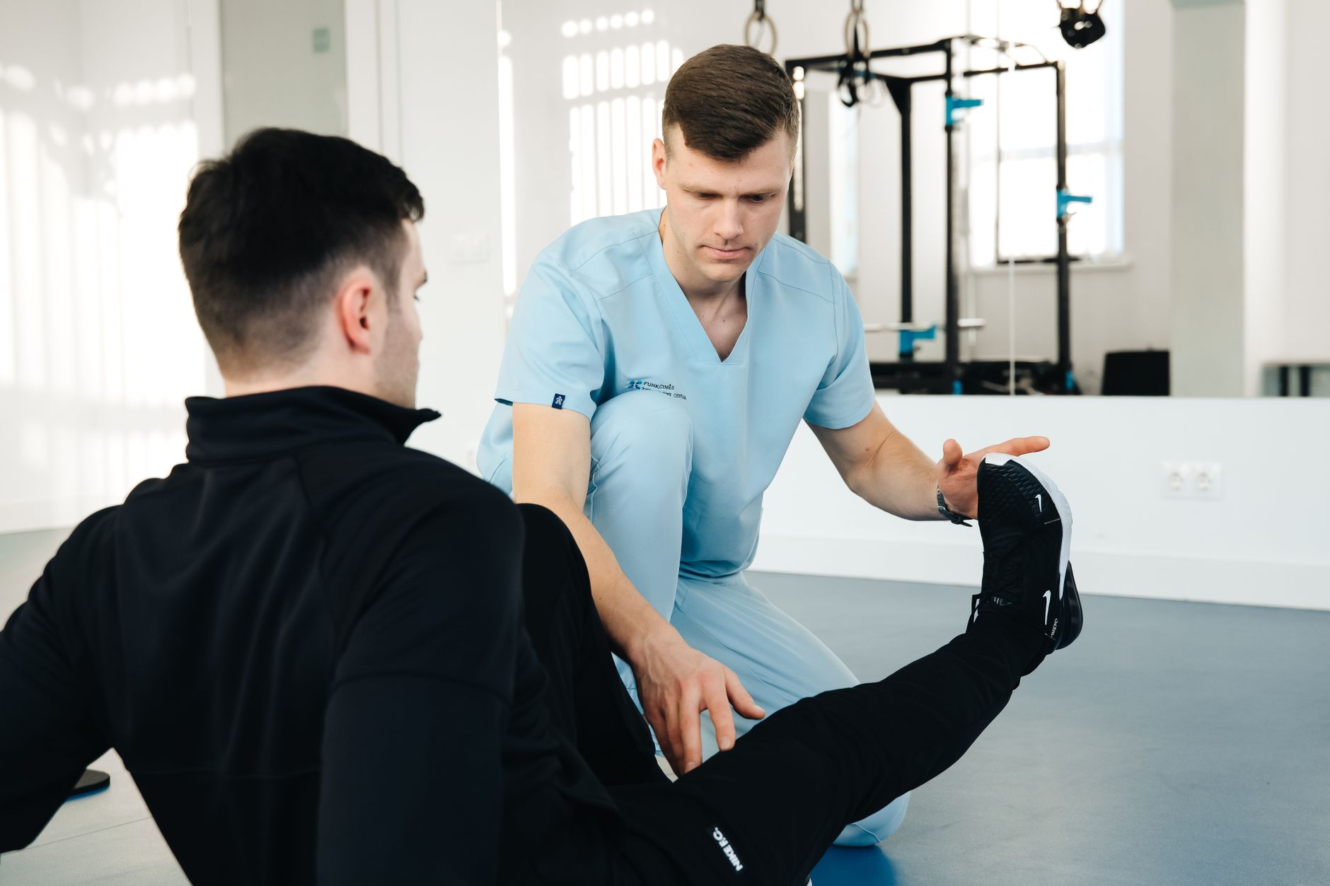 A physiotherapist greeting a returning patient at the clinic entrance