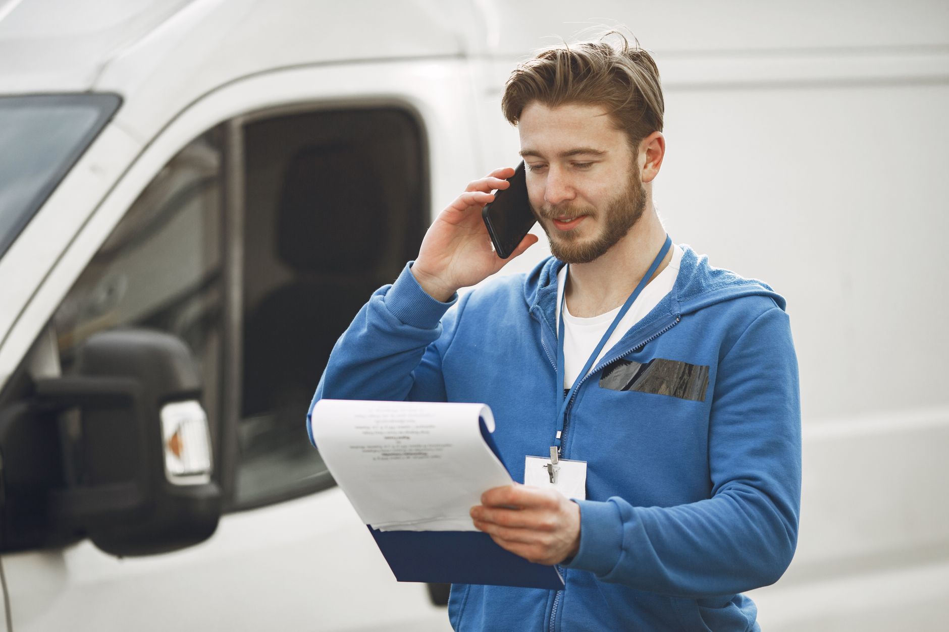 A plumber checking his phone for the next job in his van