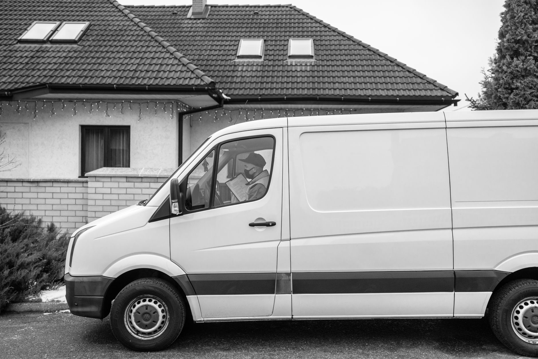 A plumber's branded van parked outside terraced houses