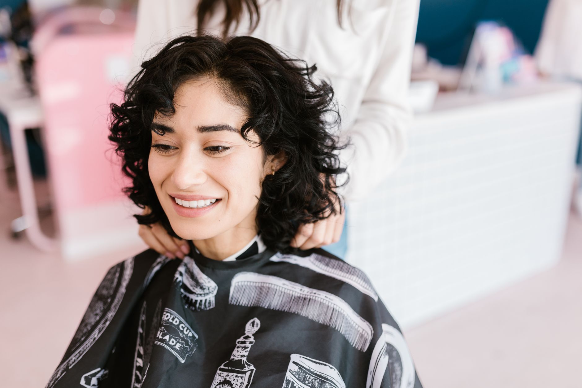 A stylist specialising in curly hair techniques with a client