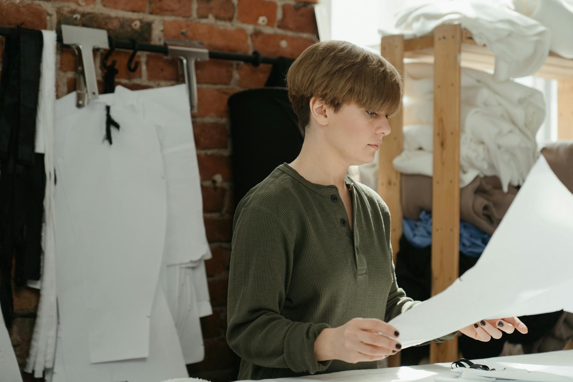 Female designer working on clothing patterns in a sewing workshop.