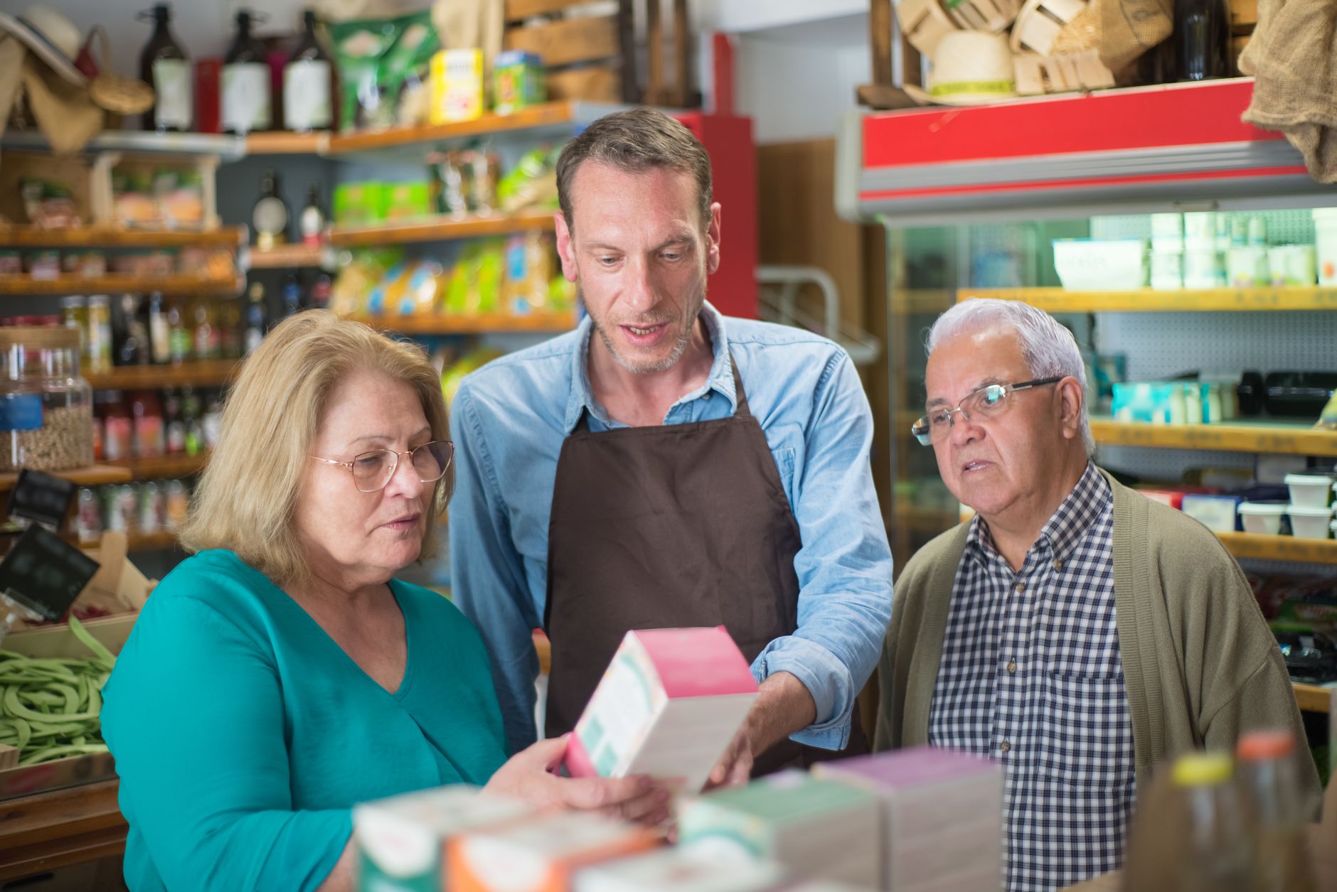 A customer weighing up two options by price in a small shop