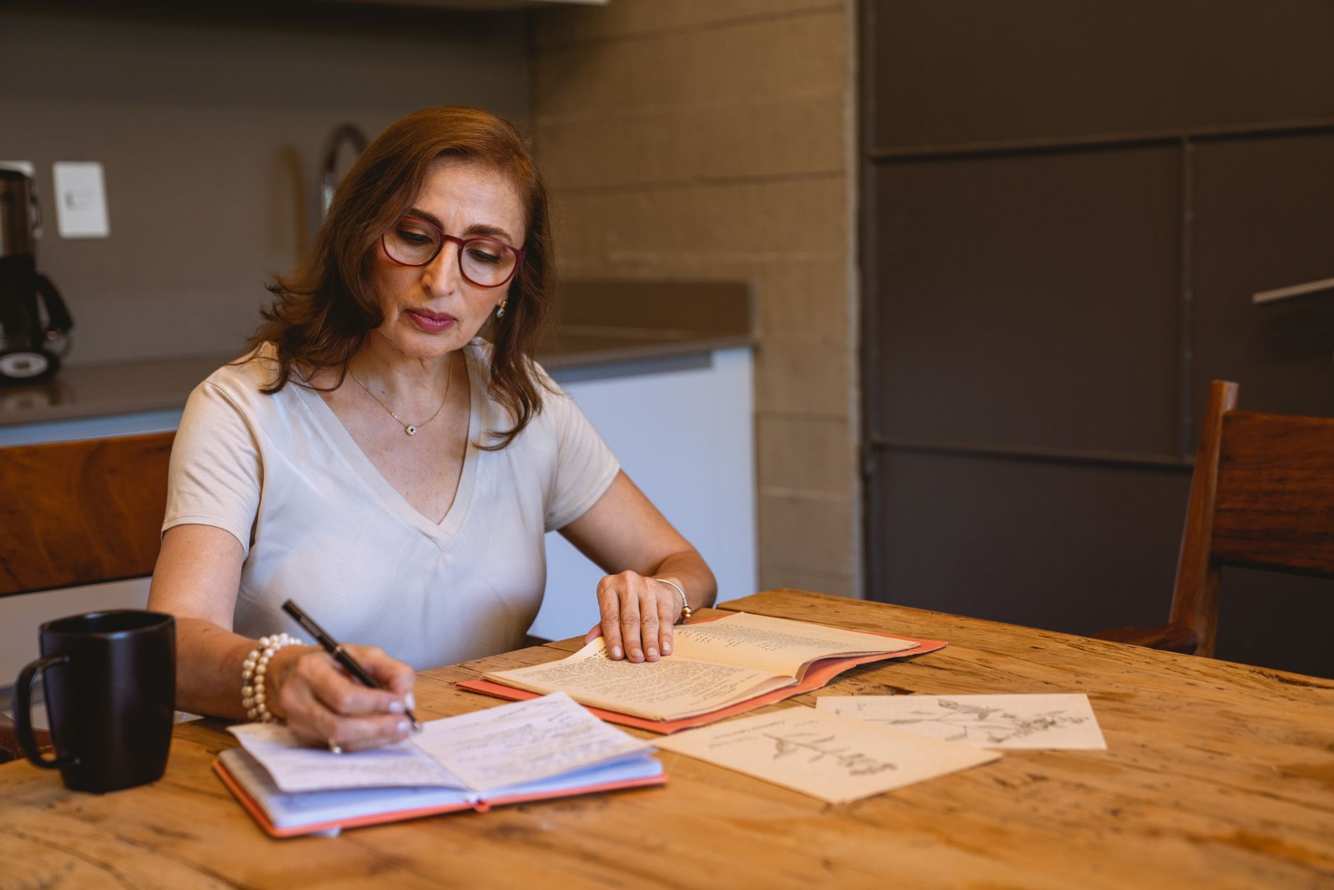 A small business owner writing out a marketing plan in a notebook