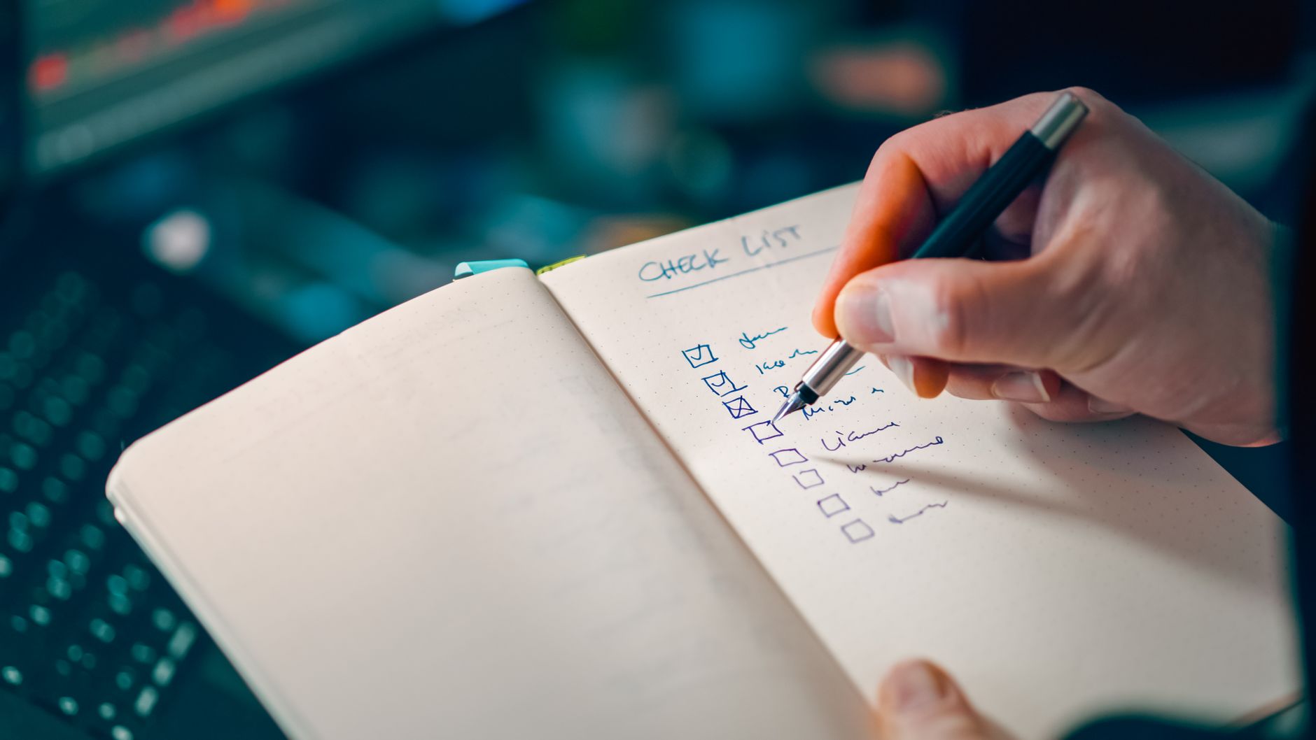 A business owner writing a short weekly task list in a notebook