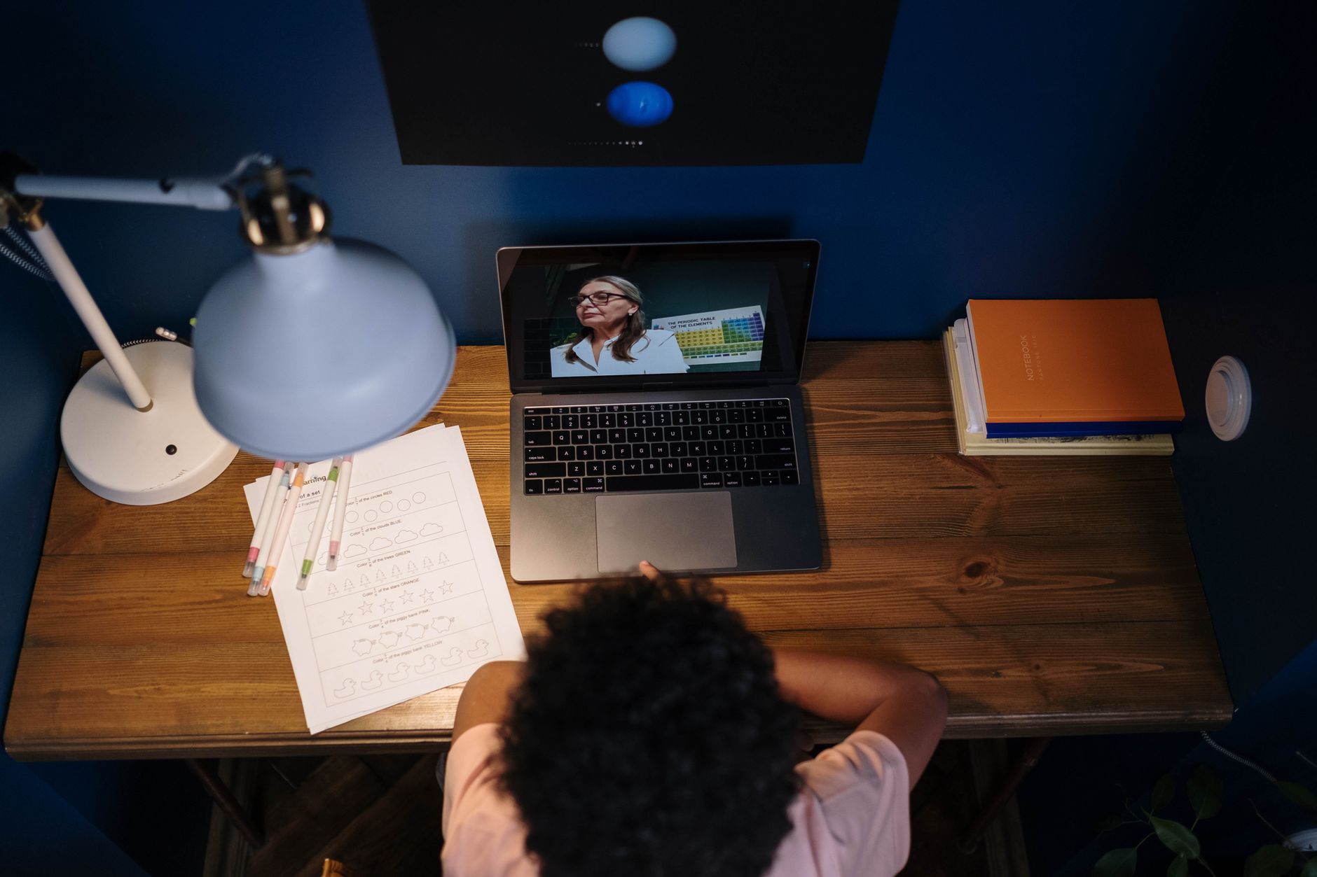 An adult learner studying an online course at home in the evening